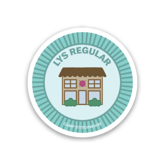 Camp Stitchwood name badge sticker featuring a playful illustration of a building with a decorative design