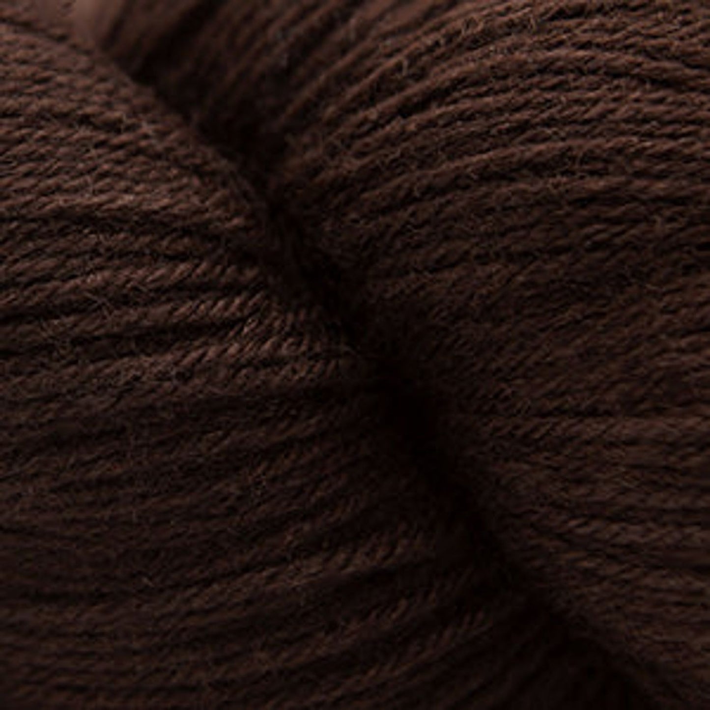 Close-up of Cascade Yarns Heritage superwash merino wool in rich brown color, perfect for soft knitting projects