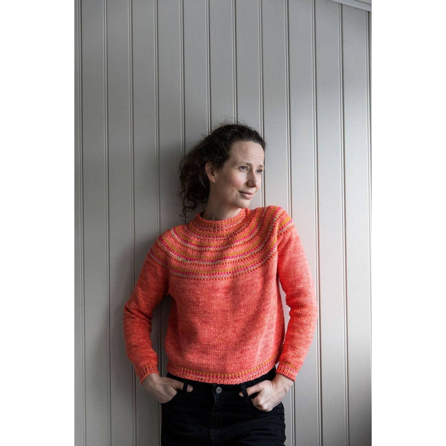 Woman wearing a pink and orange sweater showcasing chunky yarn crochet projects for stylish apparel