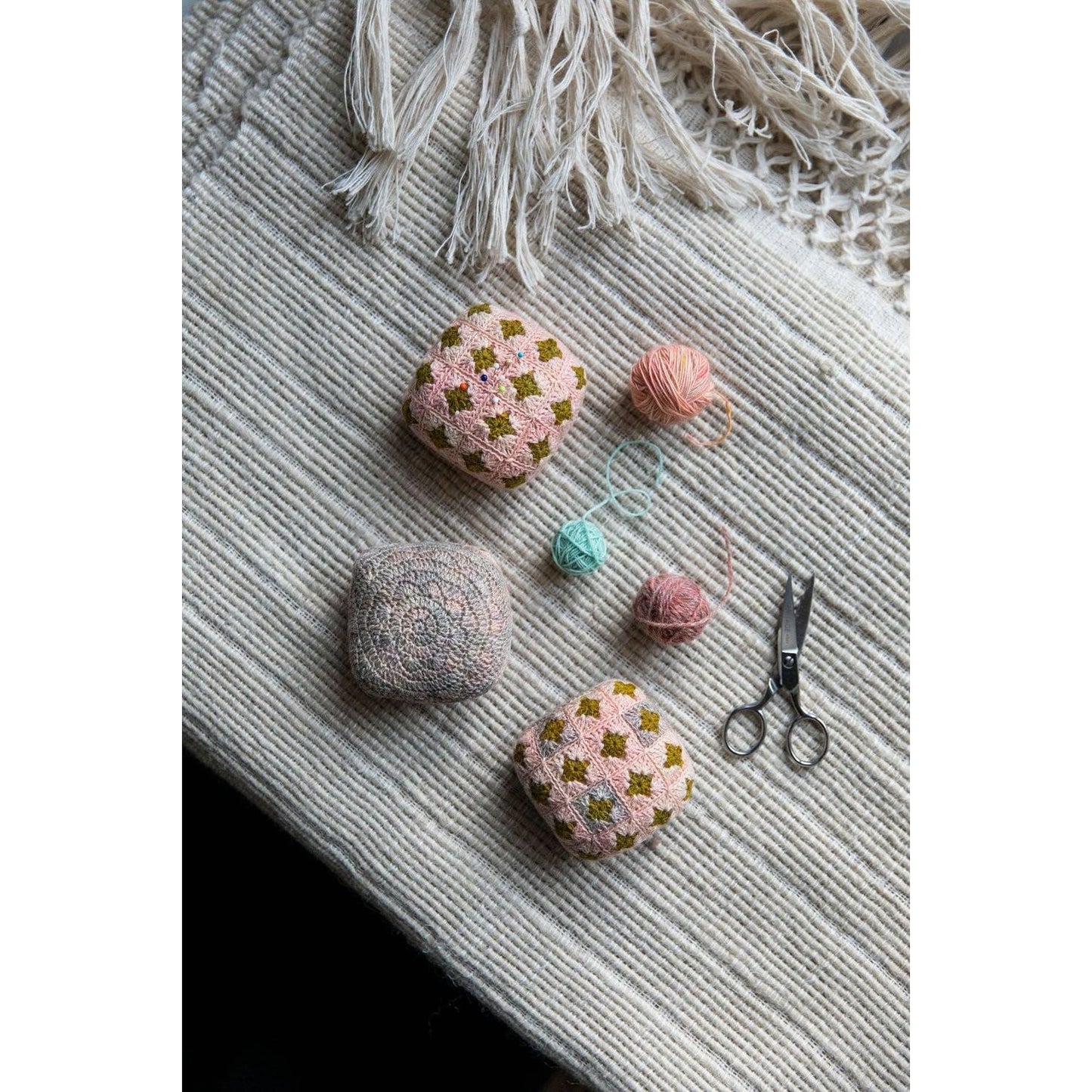 Handmade crochet pillows showcasing chunky yarn crochet projects on a textured blanket