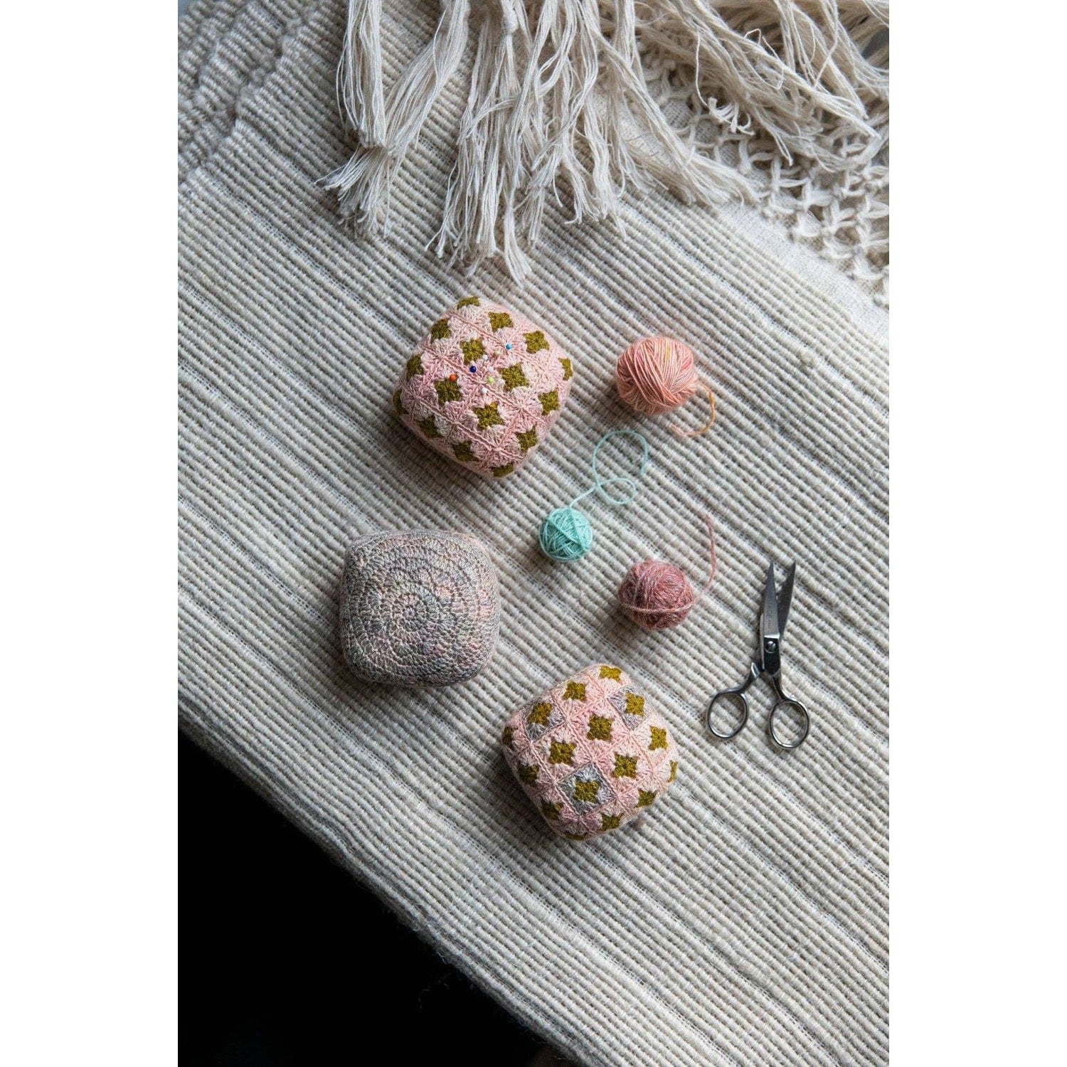 Handmade crochet pillows showcasing chunky yarn crochet projects on a textured blanket