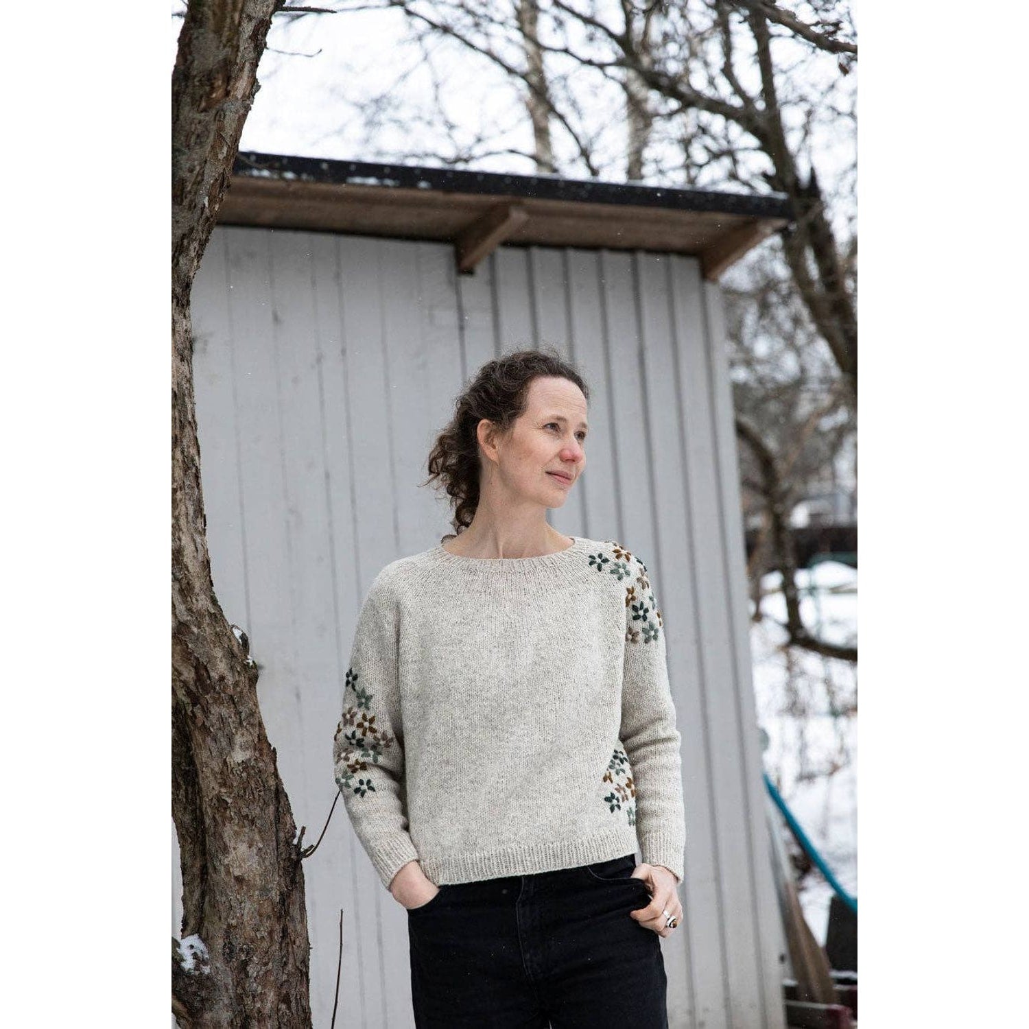 Woman wearing a cozy sweater featuring floral designs, ideal for chunky yarn crochet projects