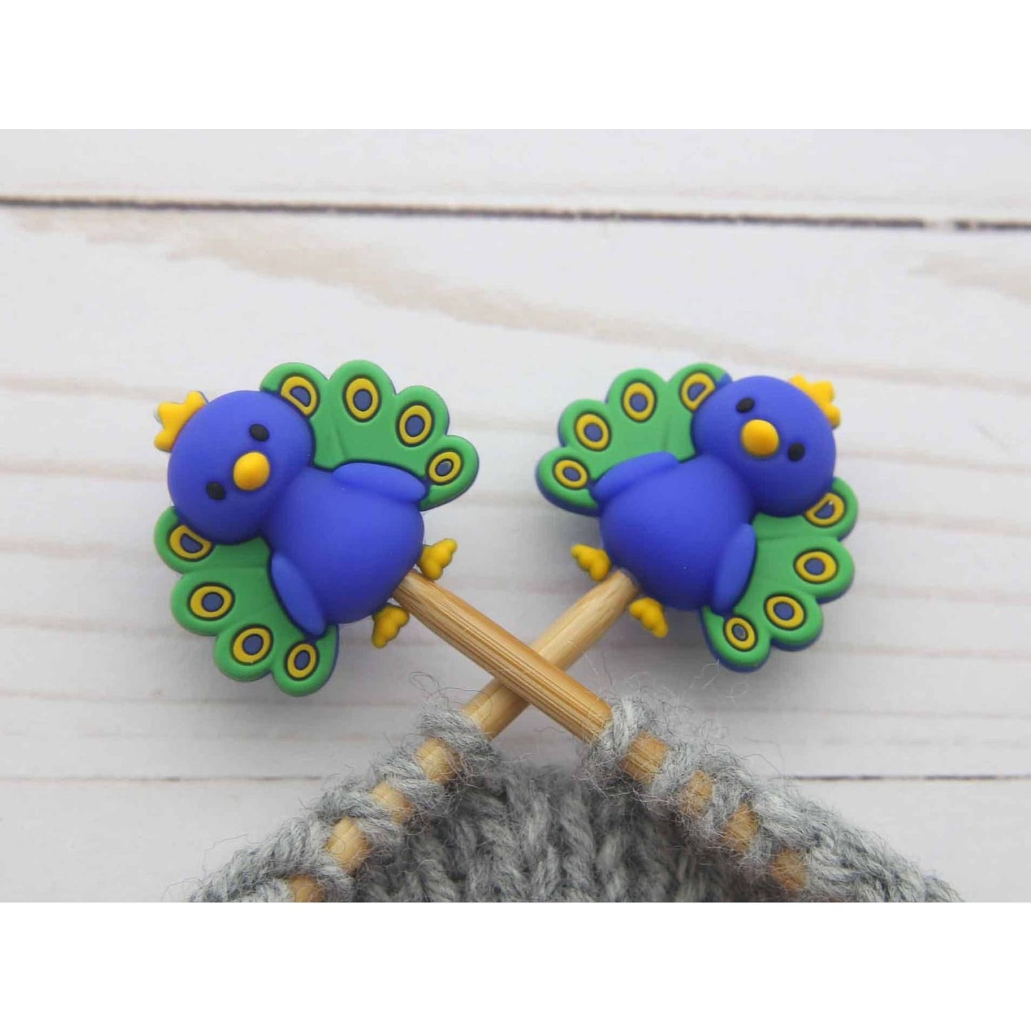 Colorful peacock stitch markers with vibrant blue and green design for knitting projects