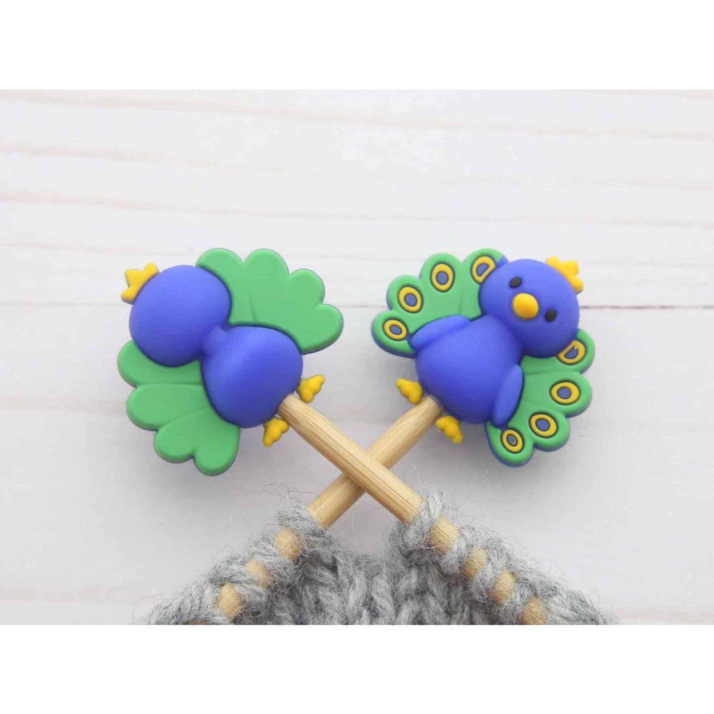 Colorful peacock knitting stitch markers featuring vibrant peacock designs on bamboo sticks