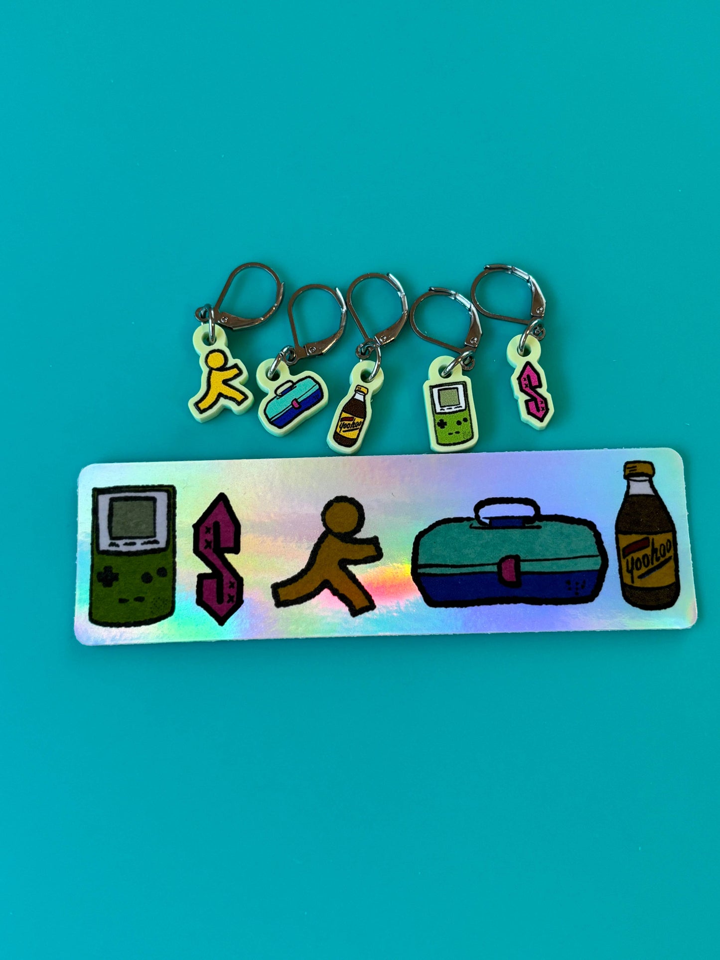 nostalgic 90s kid knitting accessories holographic tag with five stitch marker charms Game Boy running dollar sign lunchbox