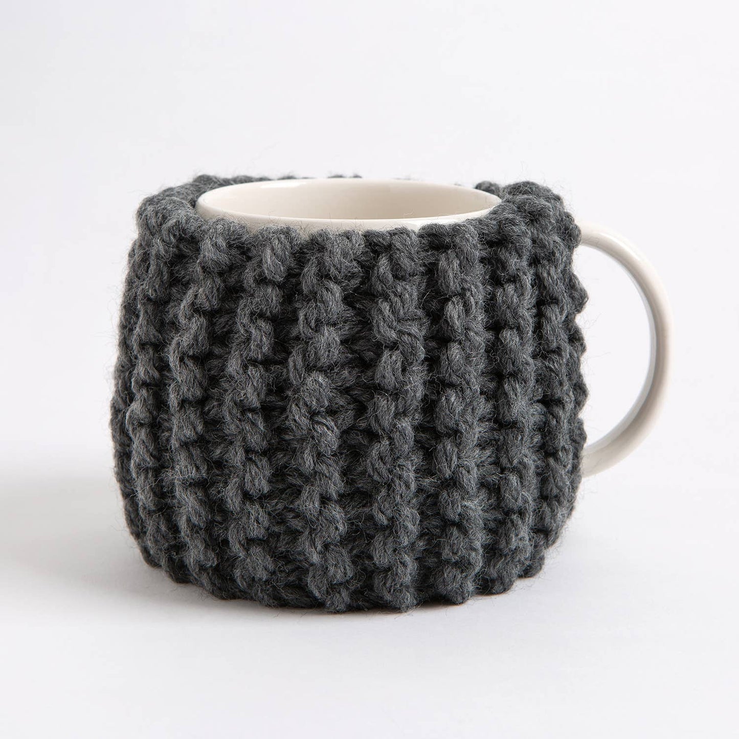 Wool Couture Company chunky dark gray knit cozy wrapped around white ceramic mug beginner knitting kit for cup cozy