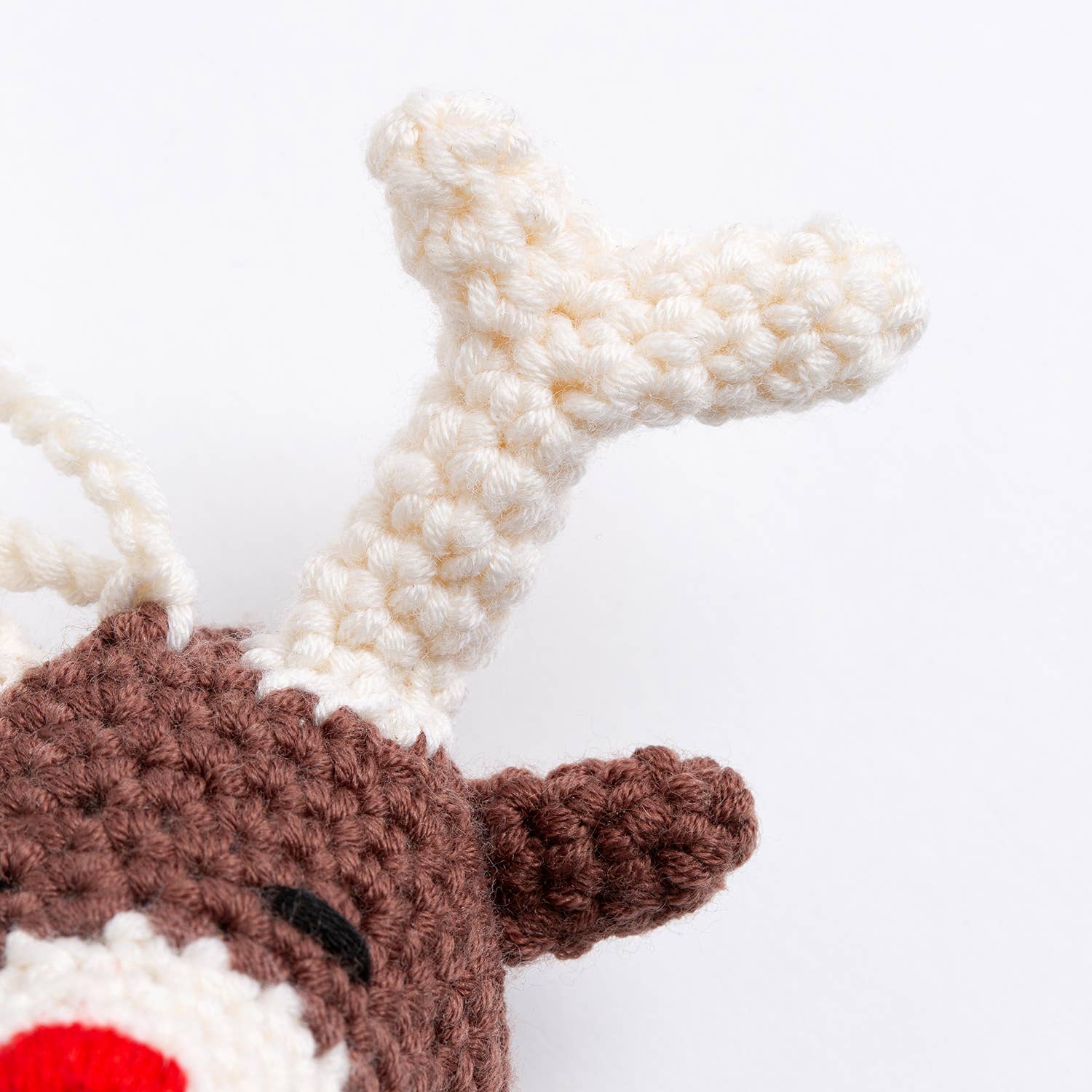 Close up of Belle the Reindeer crochet pattern showing white antler brown ear and red nose detail