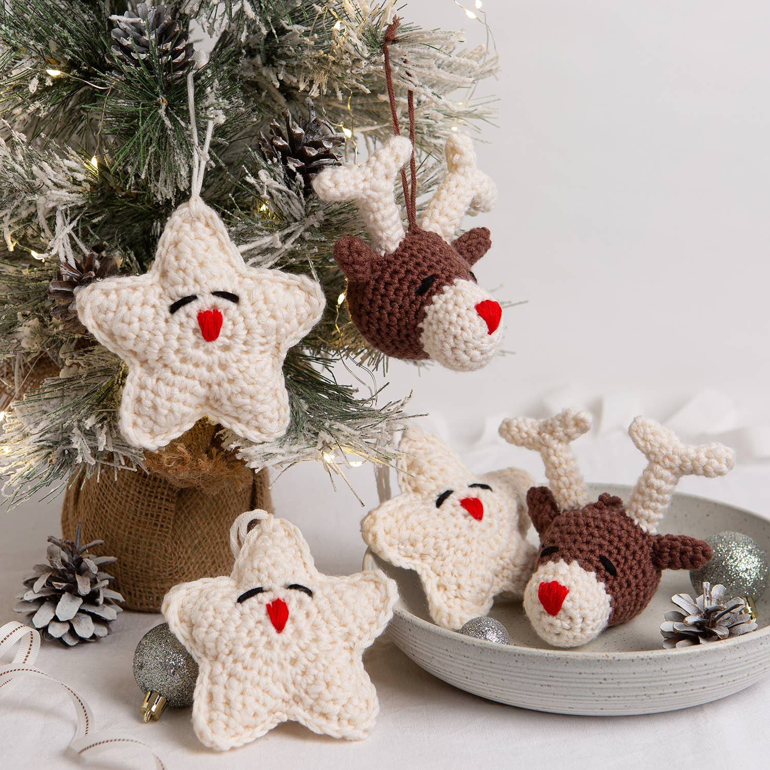 Belle the Reindeer crochet pattern with matching cream star ornaments and brown reindeer heads on holiday tree