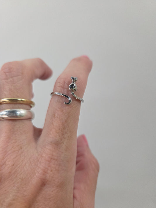 Silver cat shaped adjustable ring on index finger used as crochet accessories for tension control