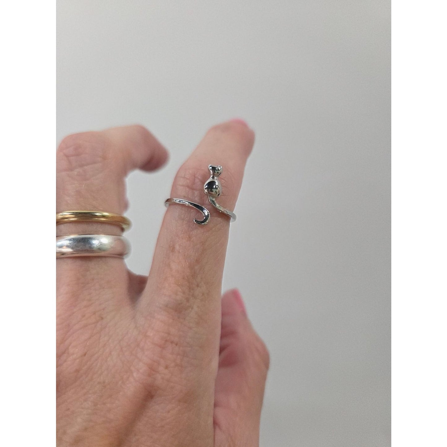 Silver cat shaped adjustable ring on index finger used as crochet accessories for tension control