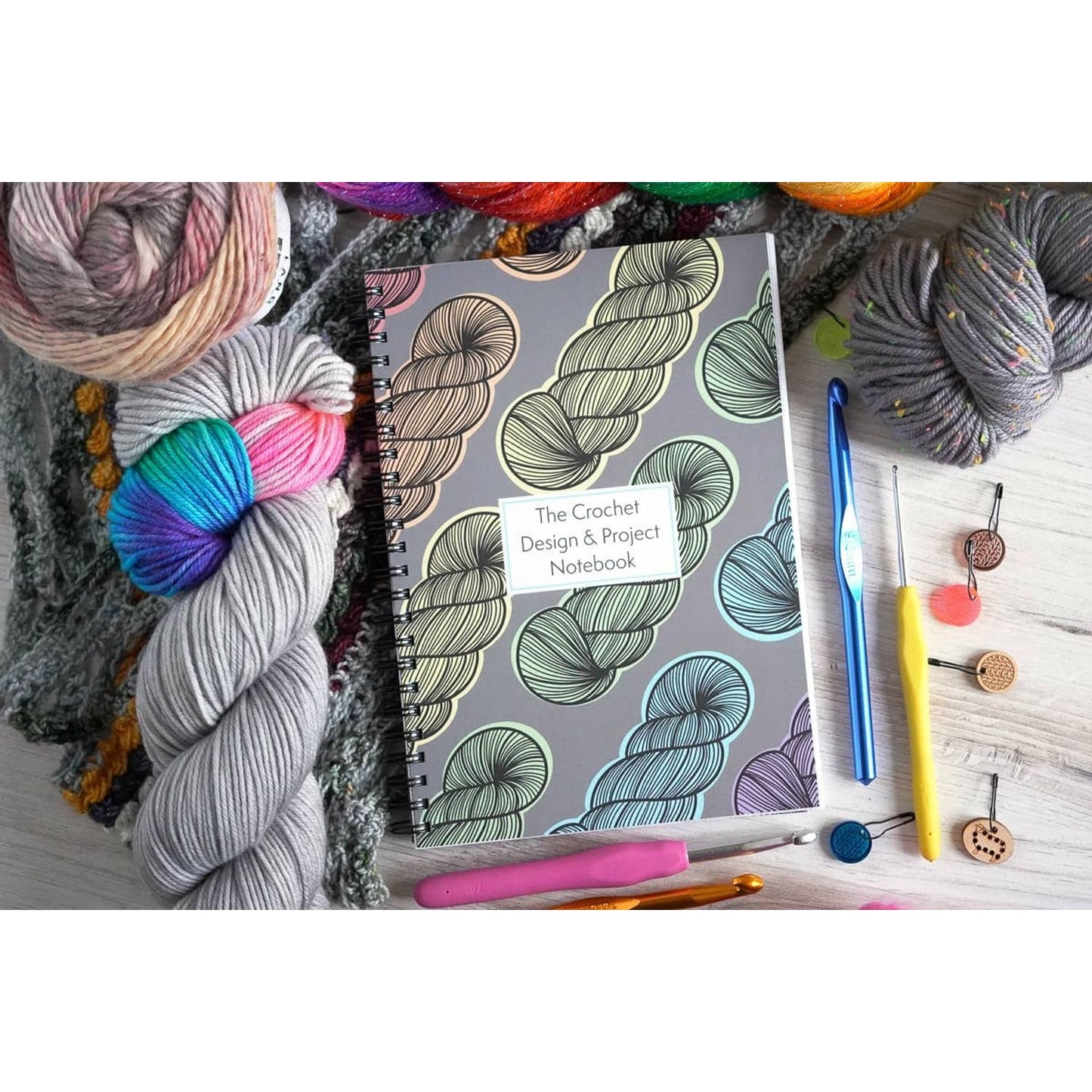 Crochet project journal for patterns with colorful yarn, crochet hooks, and stitch markers by Bri Larson Art
