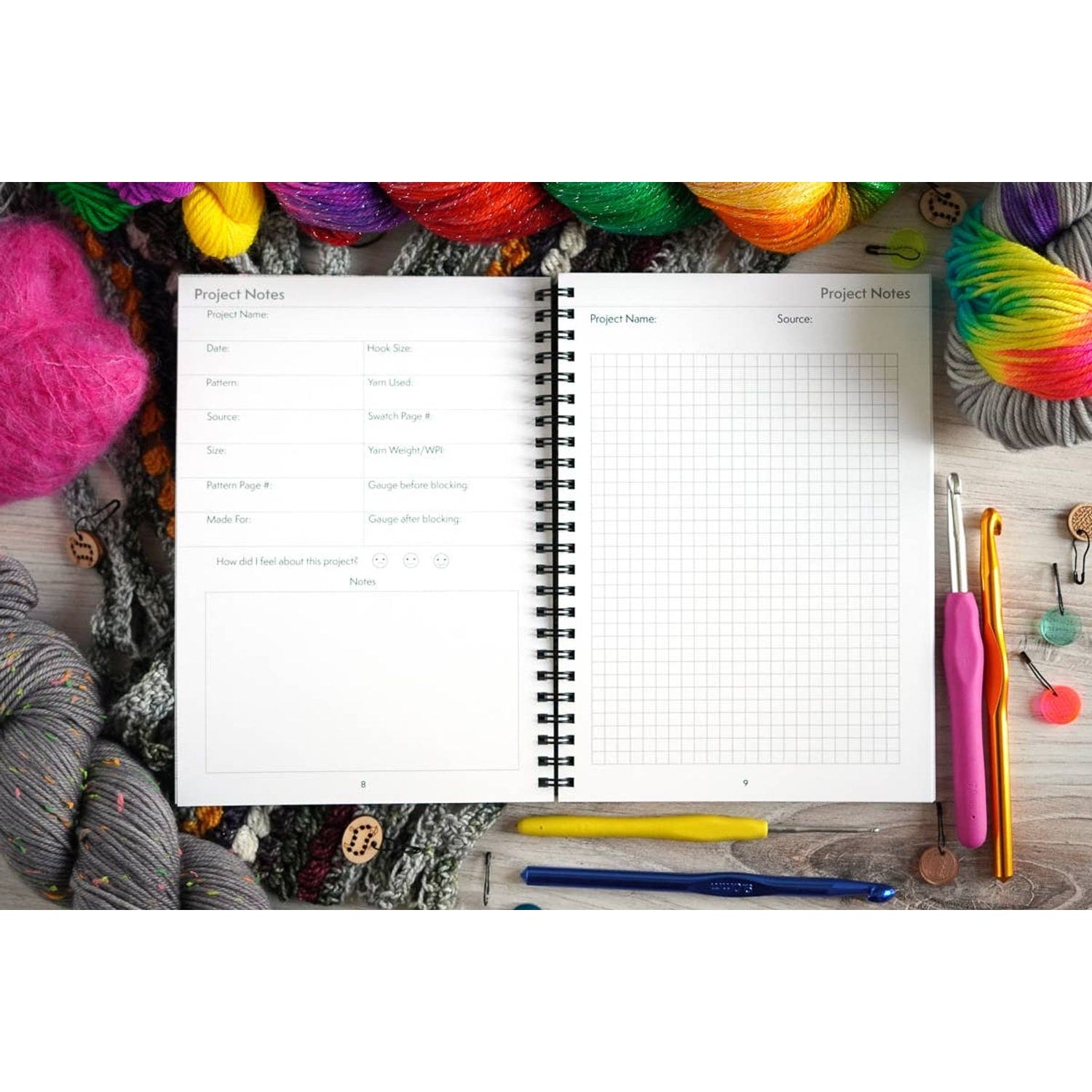 Open crochet project journal for patterns surrounded by colorful yarn and crochet hooks on wooden surface