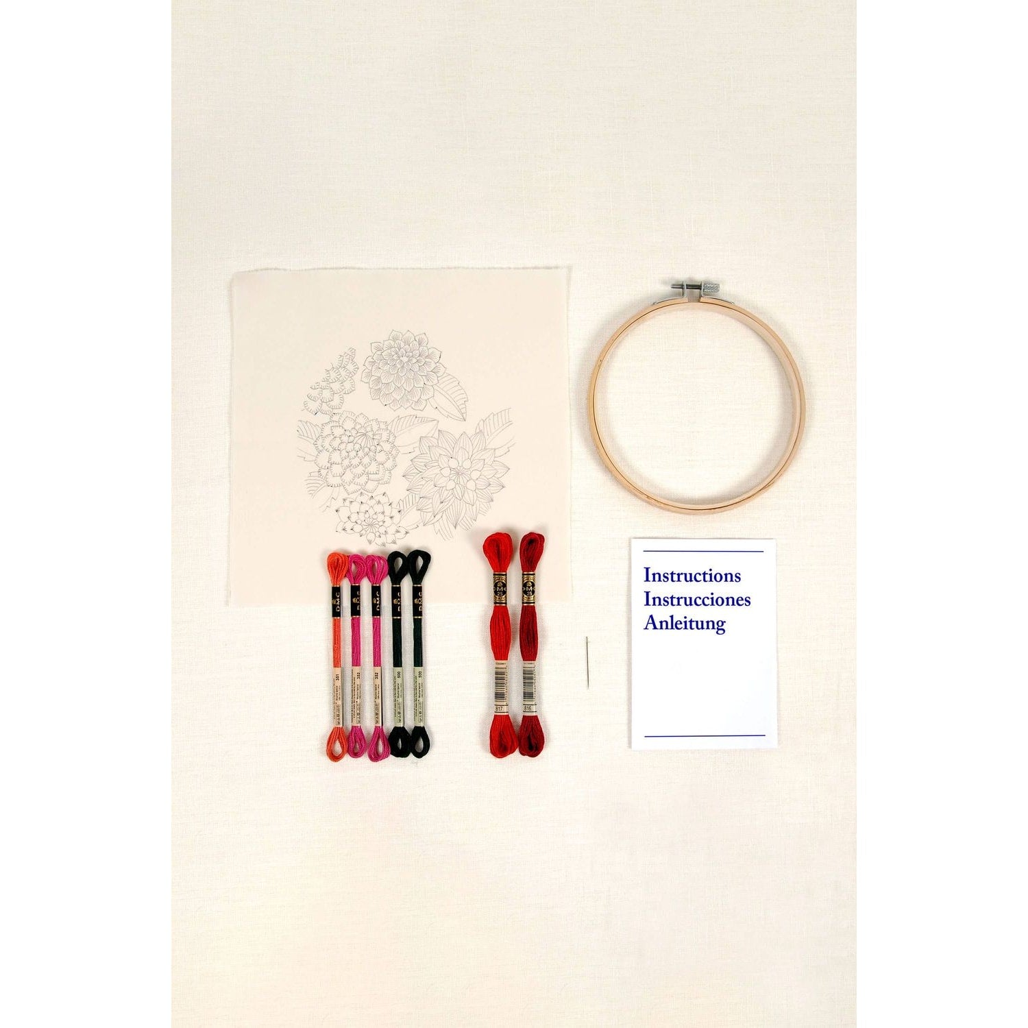 DMC embroidery kit featuring dahlias, threads, embroidery hoop, needle, and instructions for crafting