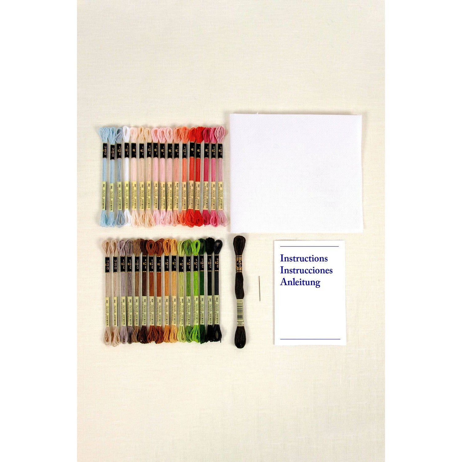 DMC embroidery kit with colorful threads, cloth, needle, and instructions featuring the Eiffel Tower design
