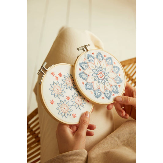 DMC kit embroidery featuring floral designs in blue and pink on wooden hoops