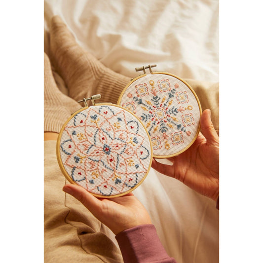 DMC Cross-Stitch Kit showcasing colorful mandala scrubs designs in embroidery hoops