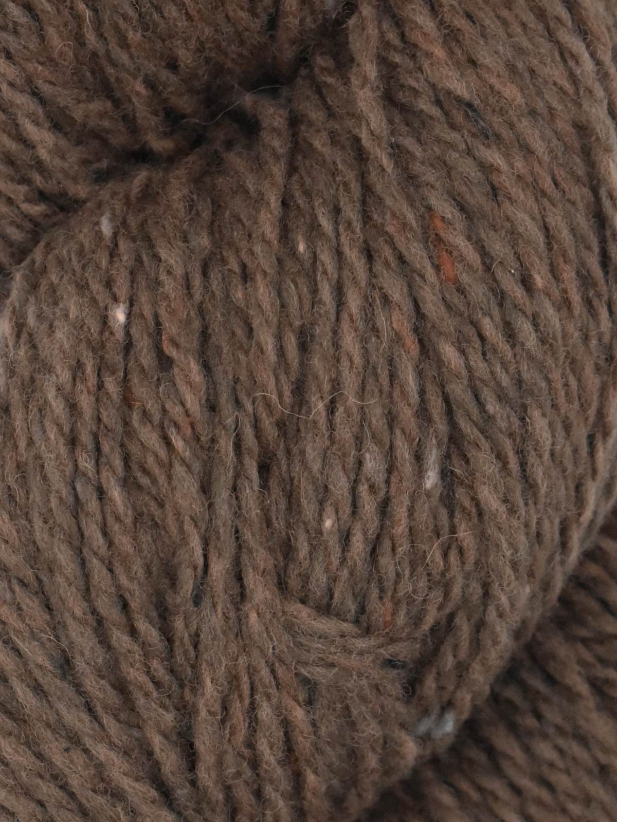 Close-up of Ella Rae Eco Tweed yarn in rich brown hues with a textured finish