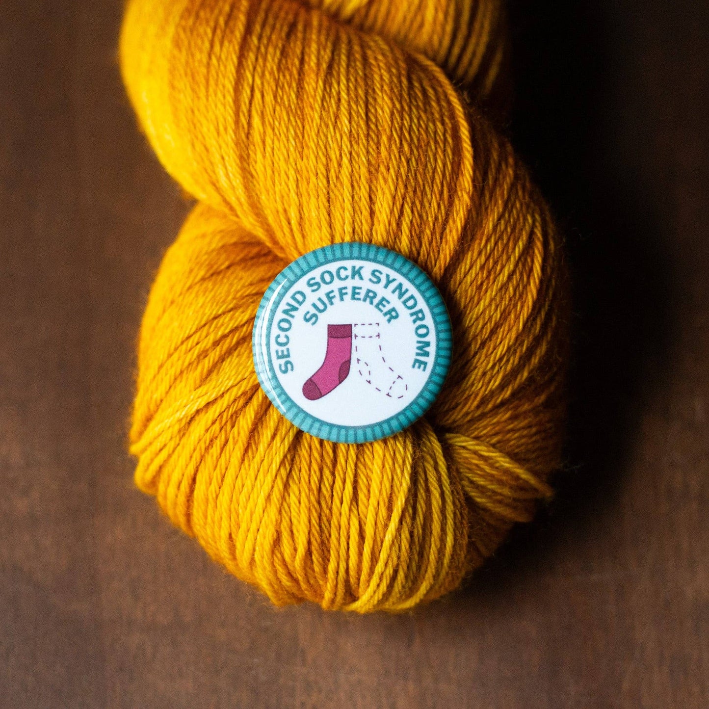 Camp Stitchwood Second Sock Syndrome Iron On Embroidered Patch on Yellow Yarn Skein