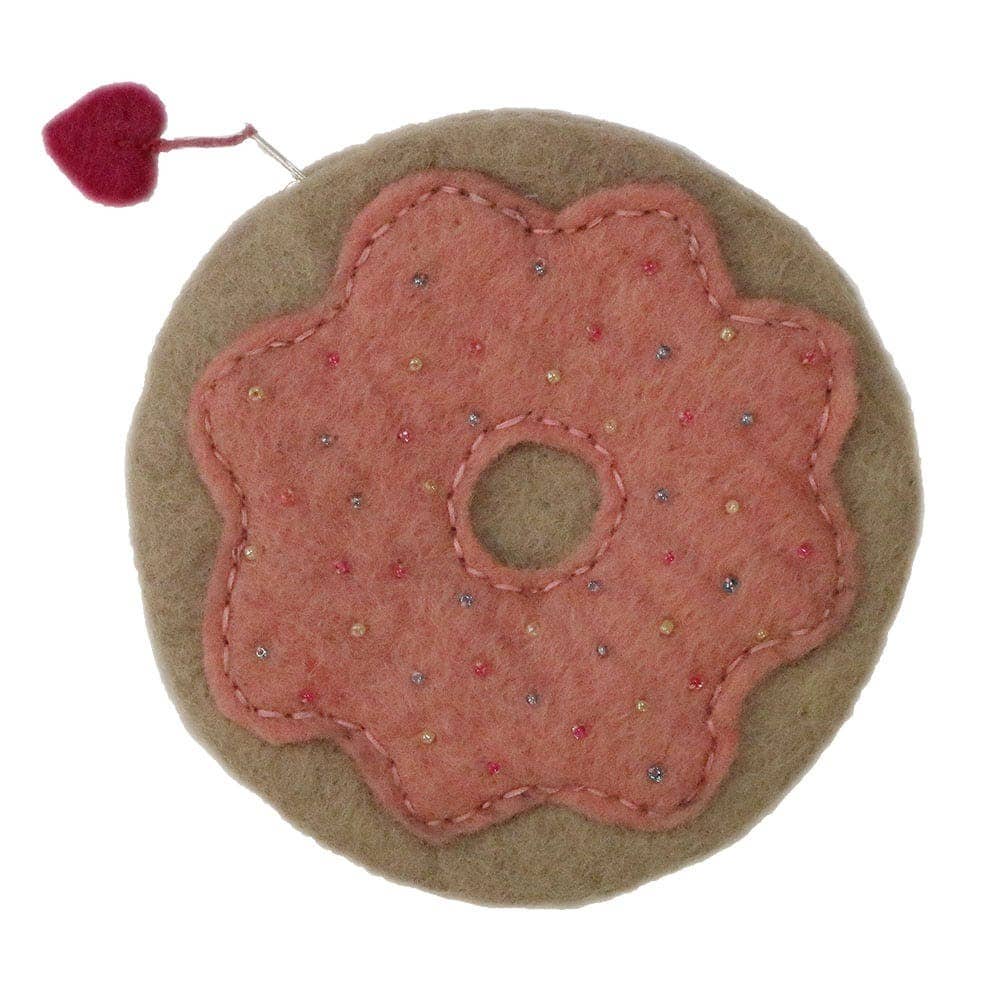Handmade pink felt bag shaped like a donut with decorative stitching and a cherry on top