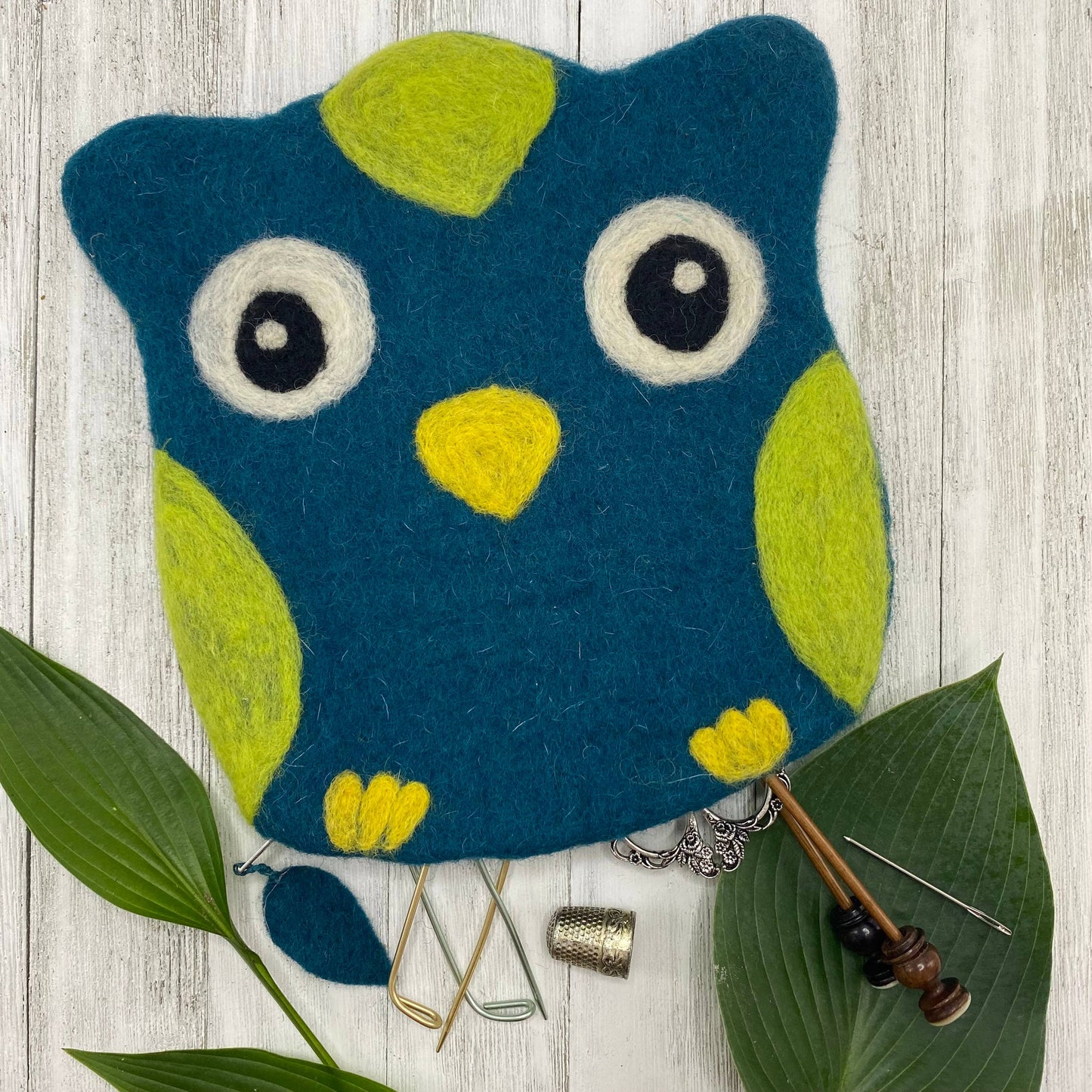 Colorful felt bag shaped like an owl with vibrant blue and green accents for storing crafting tools