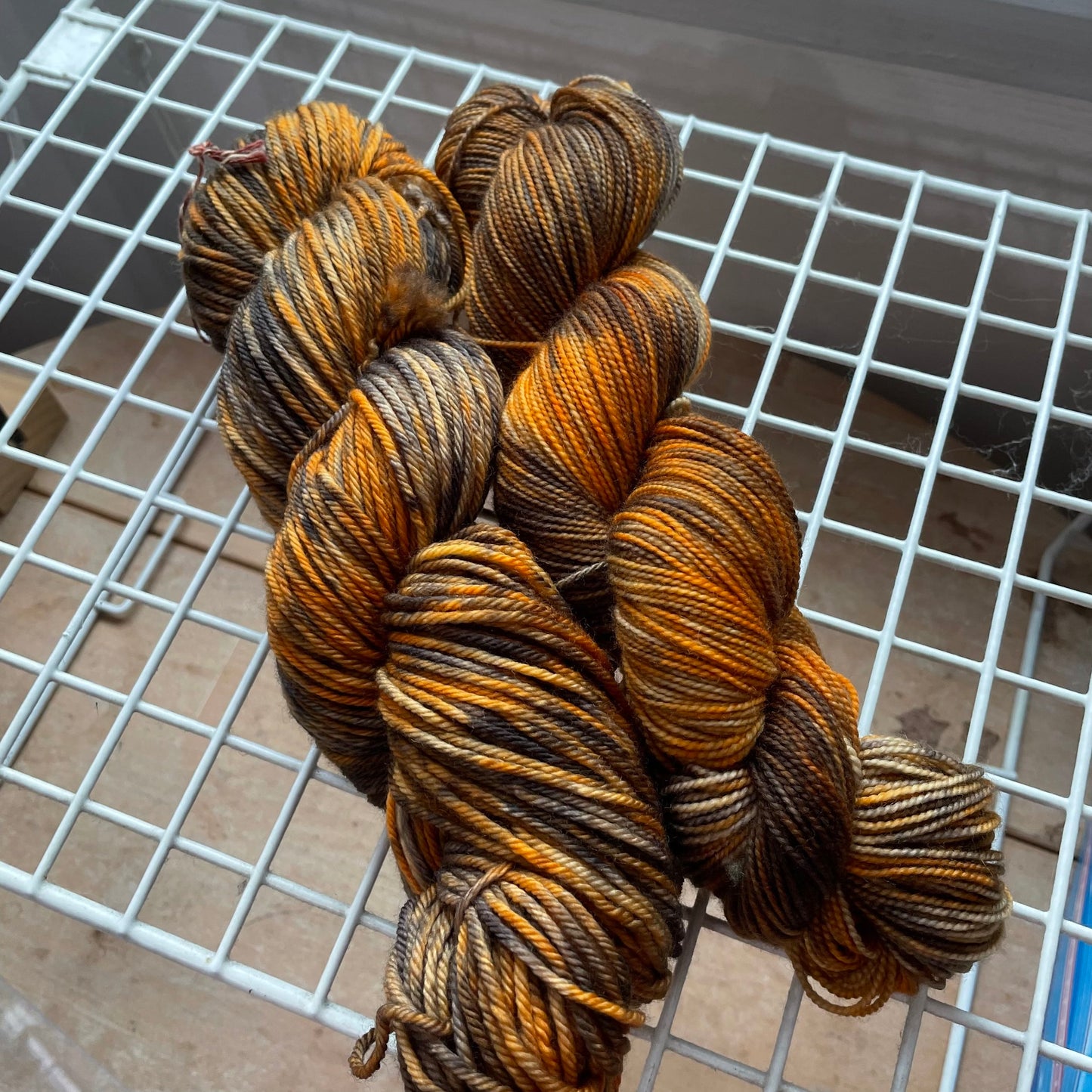 Gnome Depot Fingering Weight Yarn in rich orange and brown tones for vibrant knitting projects