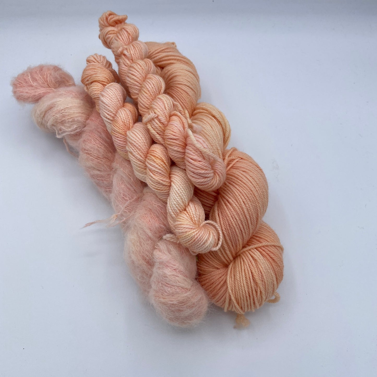 Soft gnome depot fingering weight yarn in peach tones, perfect for delicate knitting projects