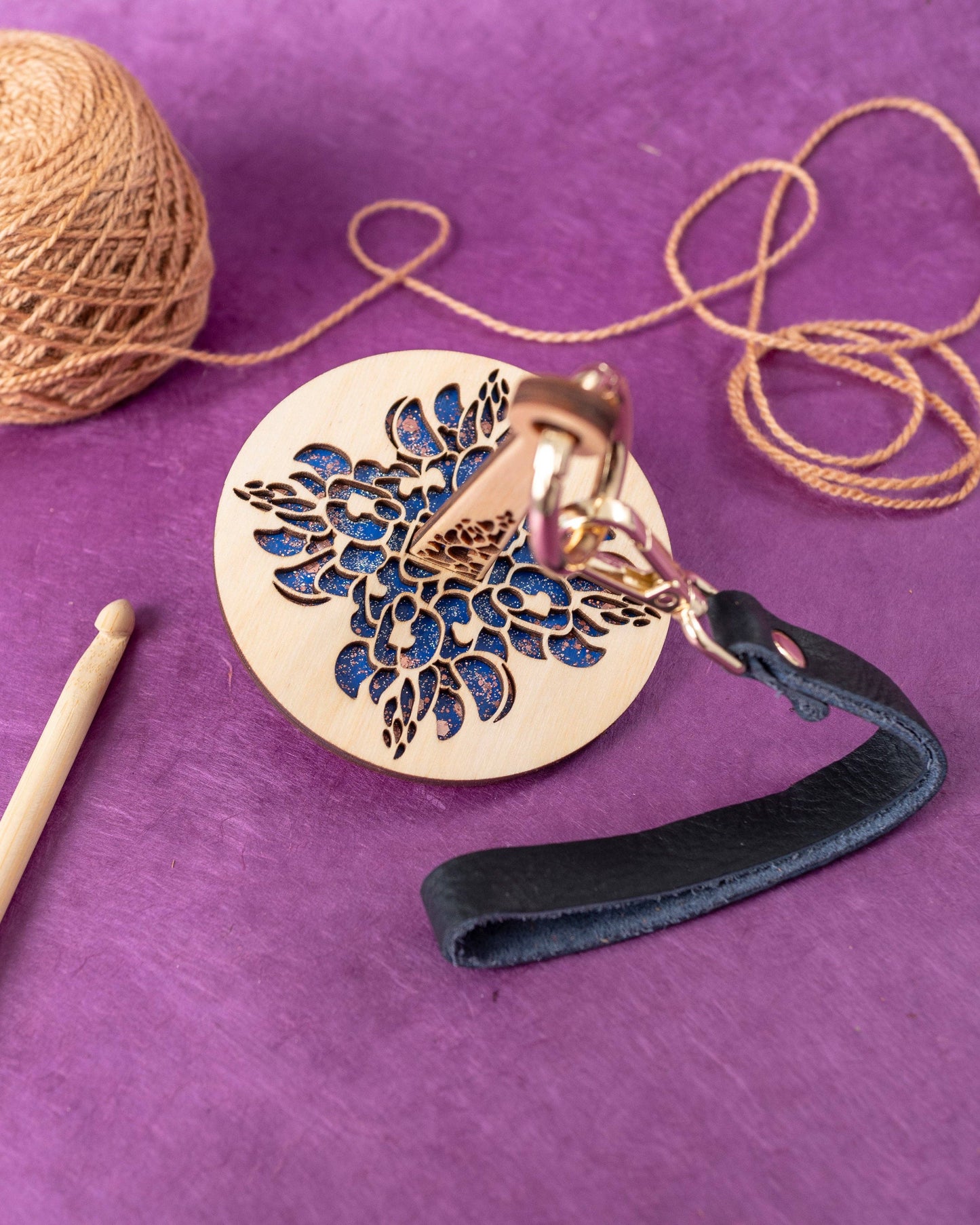 Lemonwood round wooden keychain with laser cut floral motif blue backing black leather strap and brass ring