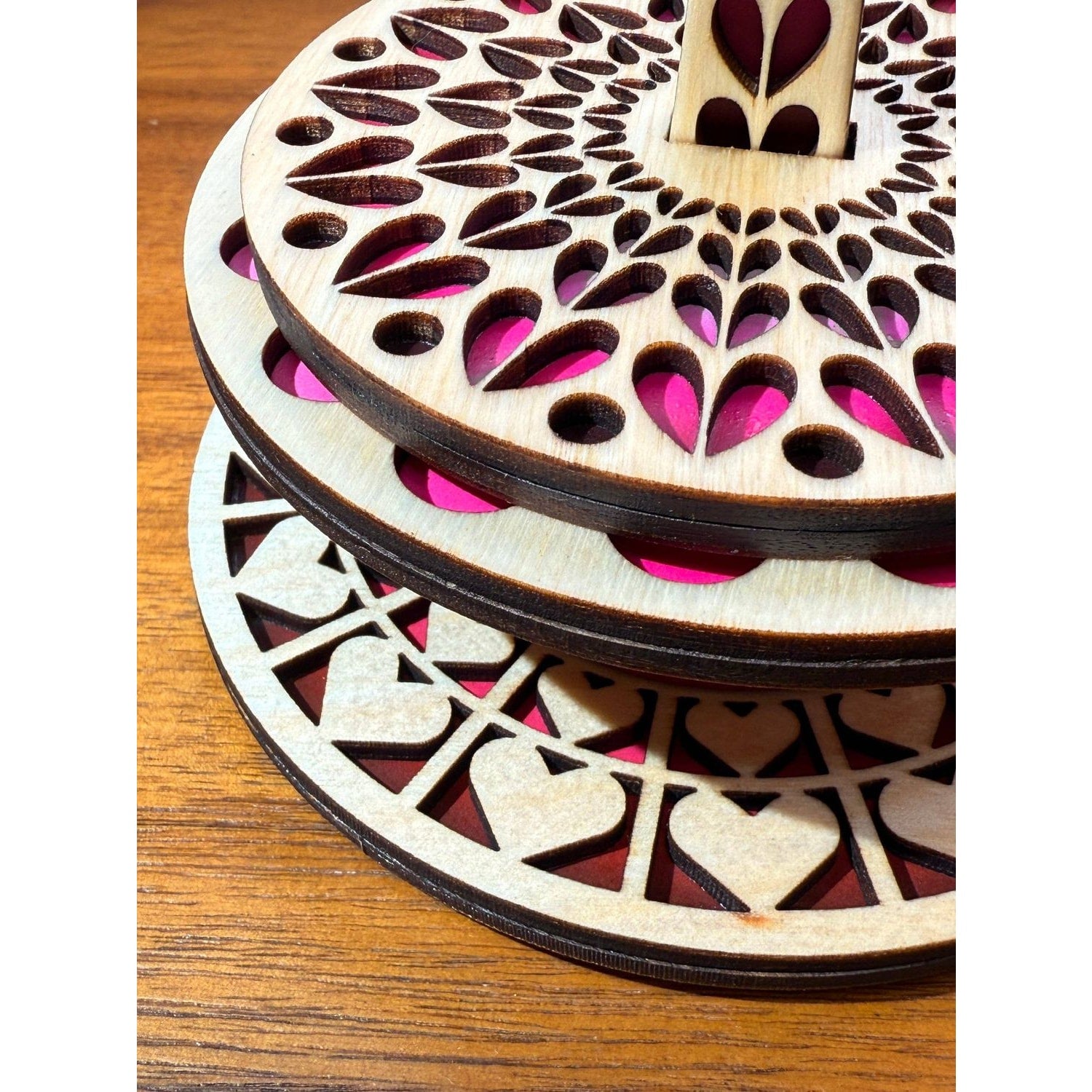 Three-tier wooden stand with intricate cutouts featuring the design of hearts queen for displaying items