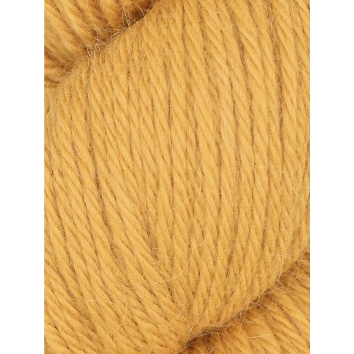 Close-up of Juniper Moon Farm Herriot yarn in soft golden color for knitting and crochet projects