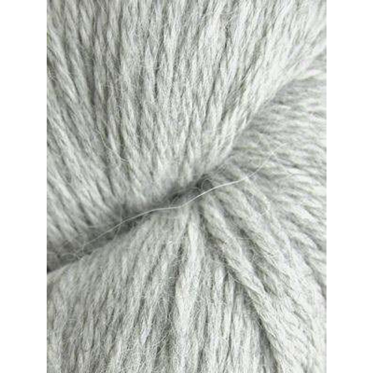 Soft gray Juniper Moon Farm Herriot yarn in a twisted skein for knitting and crochet projects