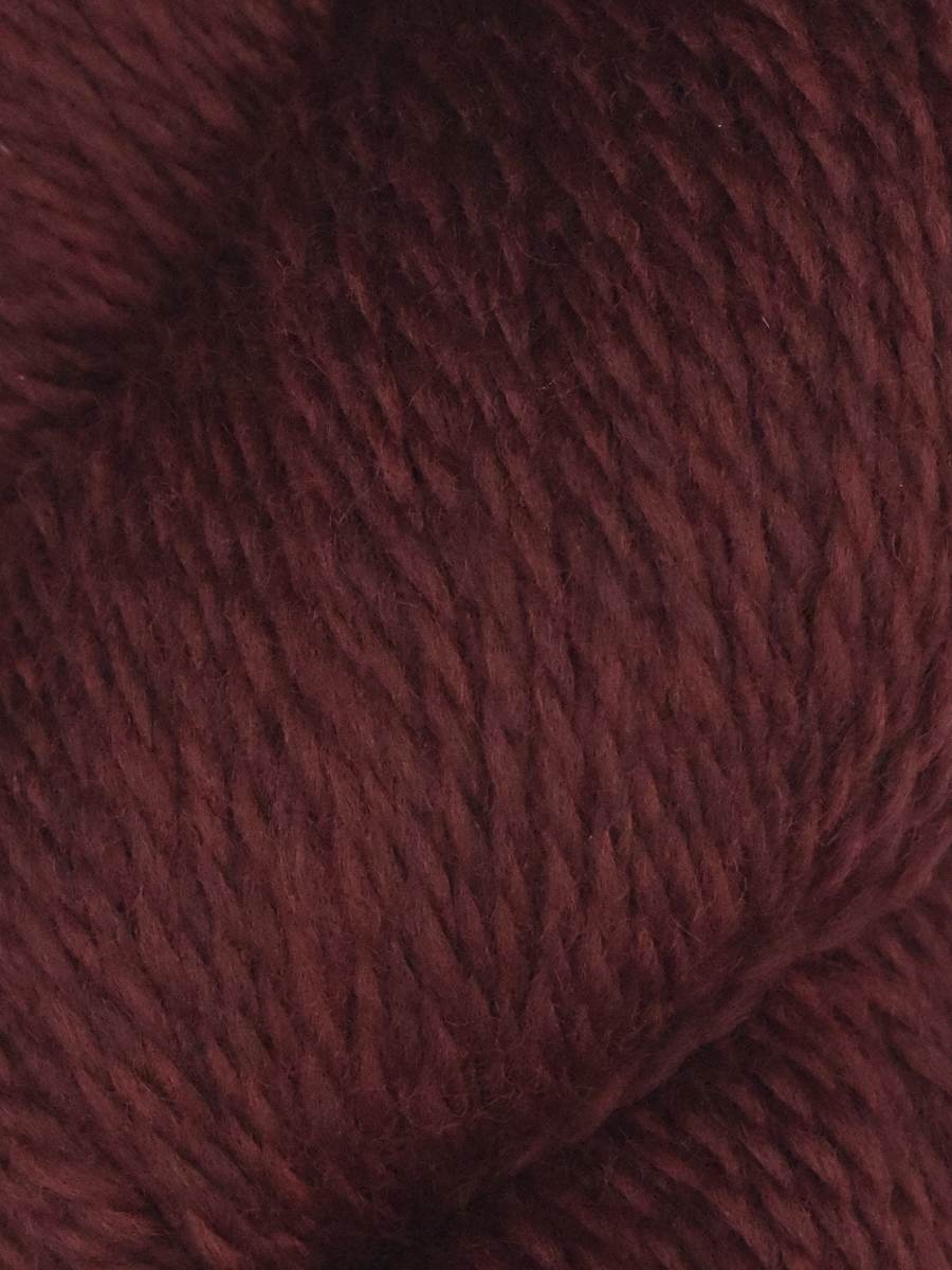Close up of deep burgundy skein of Juniper Moon Farm Rambouillet yarn by Knitting Fever showing soft plied wool texture