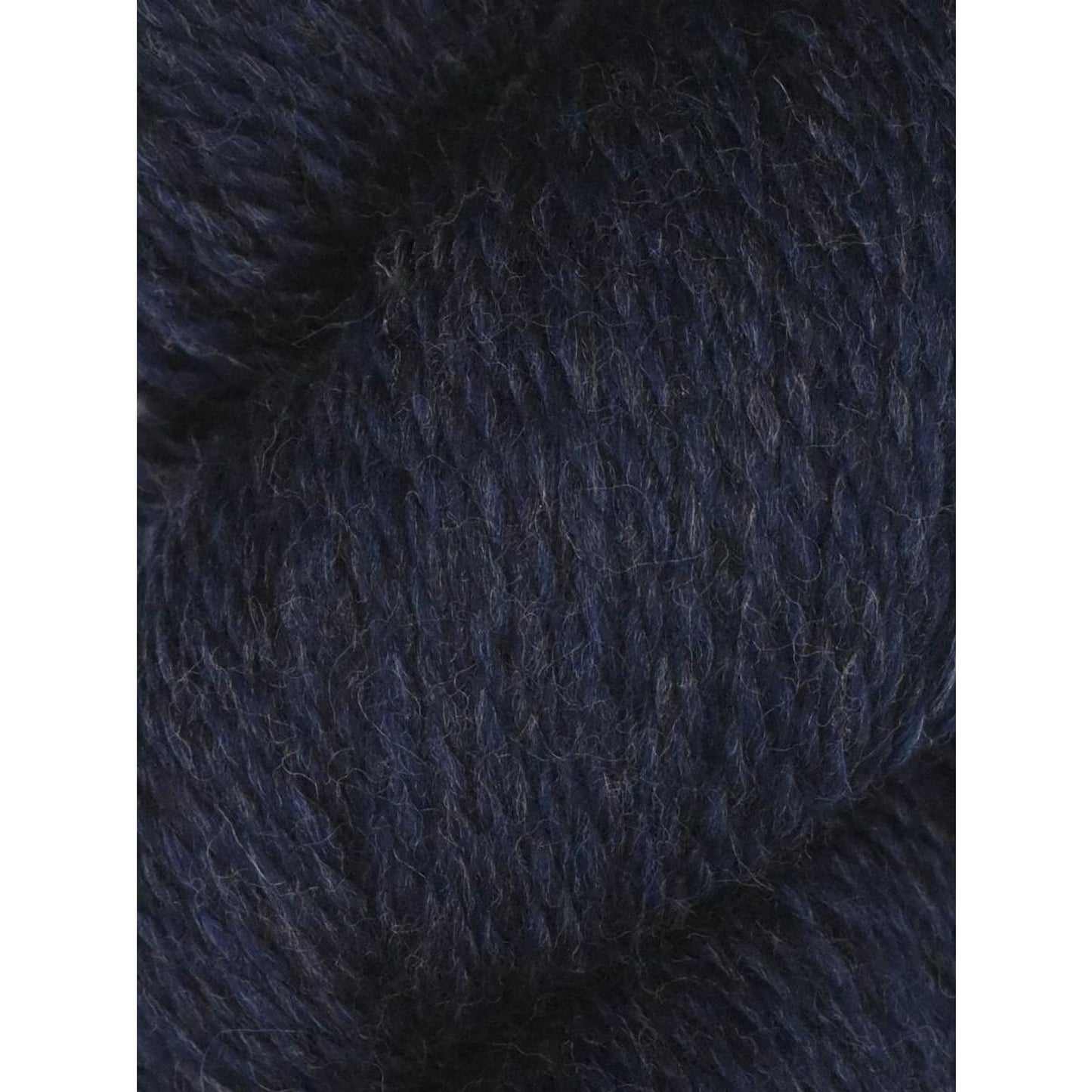 Knitting Fever skein of Juniper Moon Farm Rambouillet yarn in deep navy heather closeup showing soft wool texture