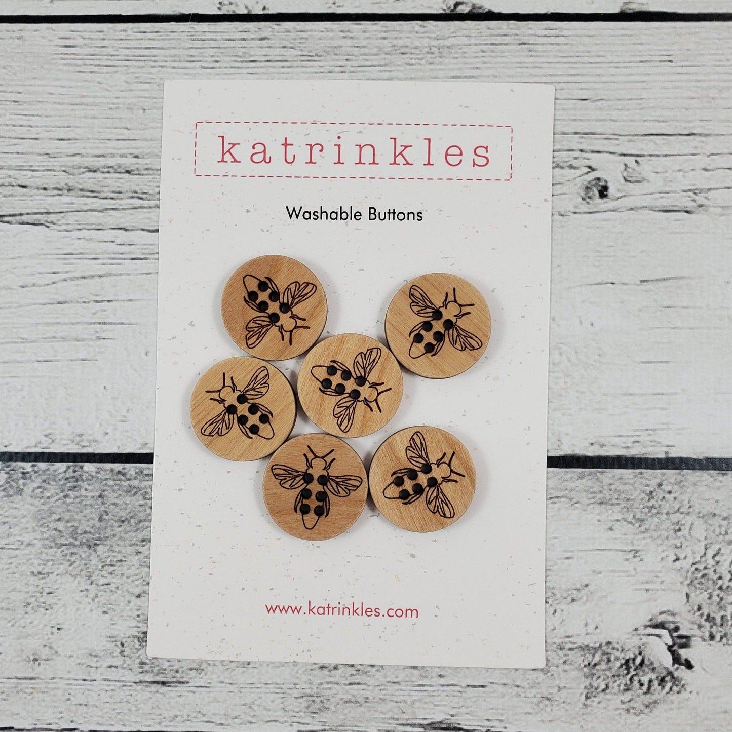 Set of six Katrinkles Washable Buttons featuring a honey bee design on natural wood