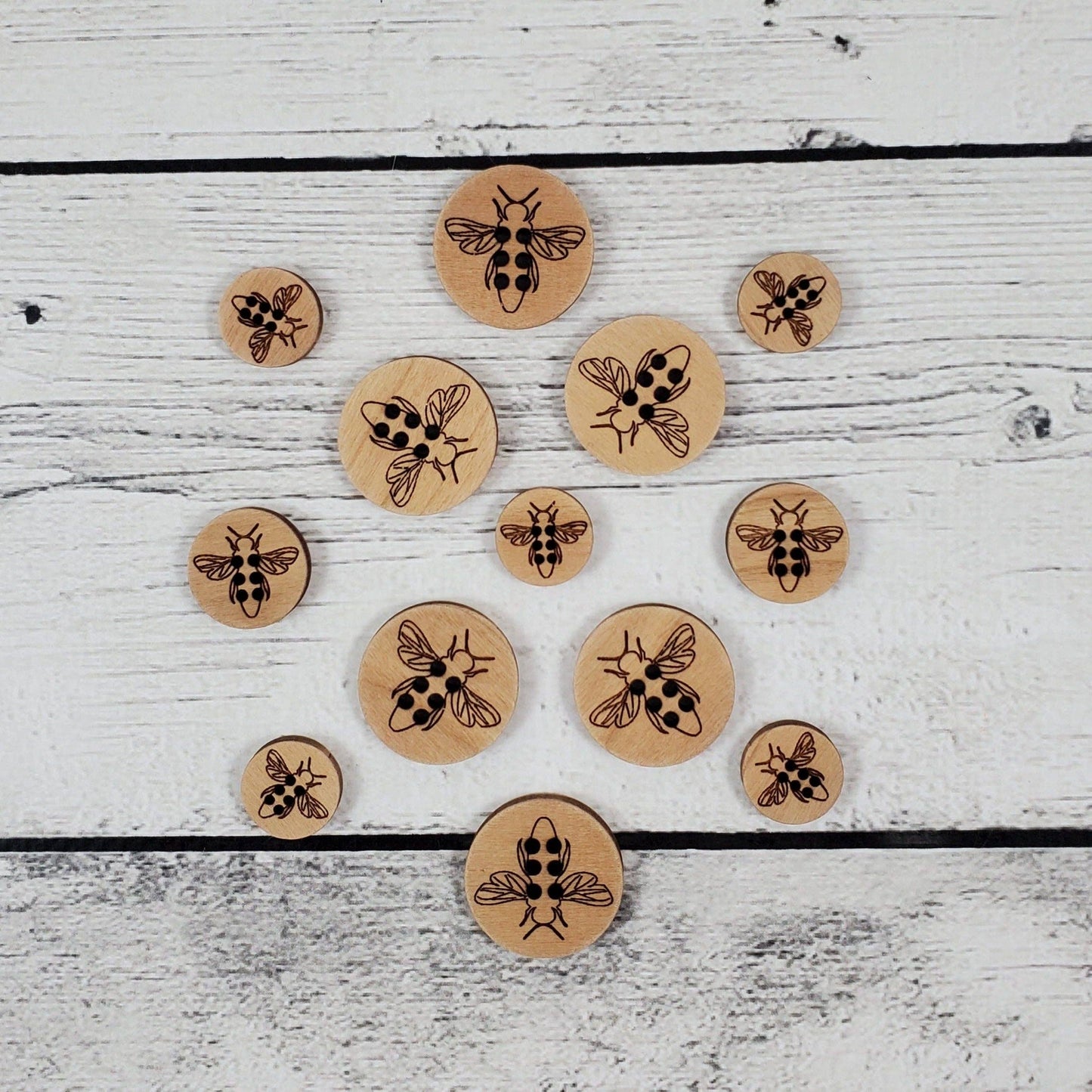 Katrinkles honey bee wood pins in various sizes featuring intricate engravings of bees