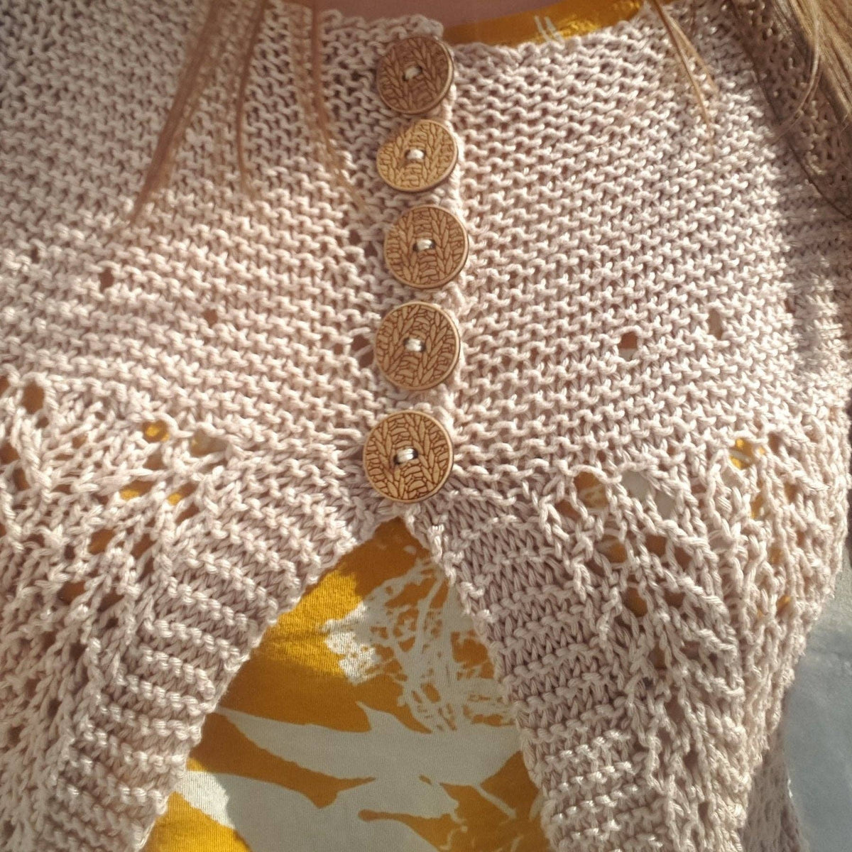 Katrinkles knitting supplies for knitting featuring a close-up of a knitted garment with wooden buttons