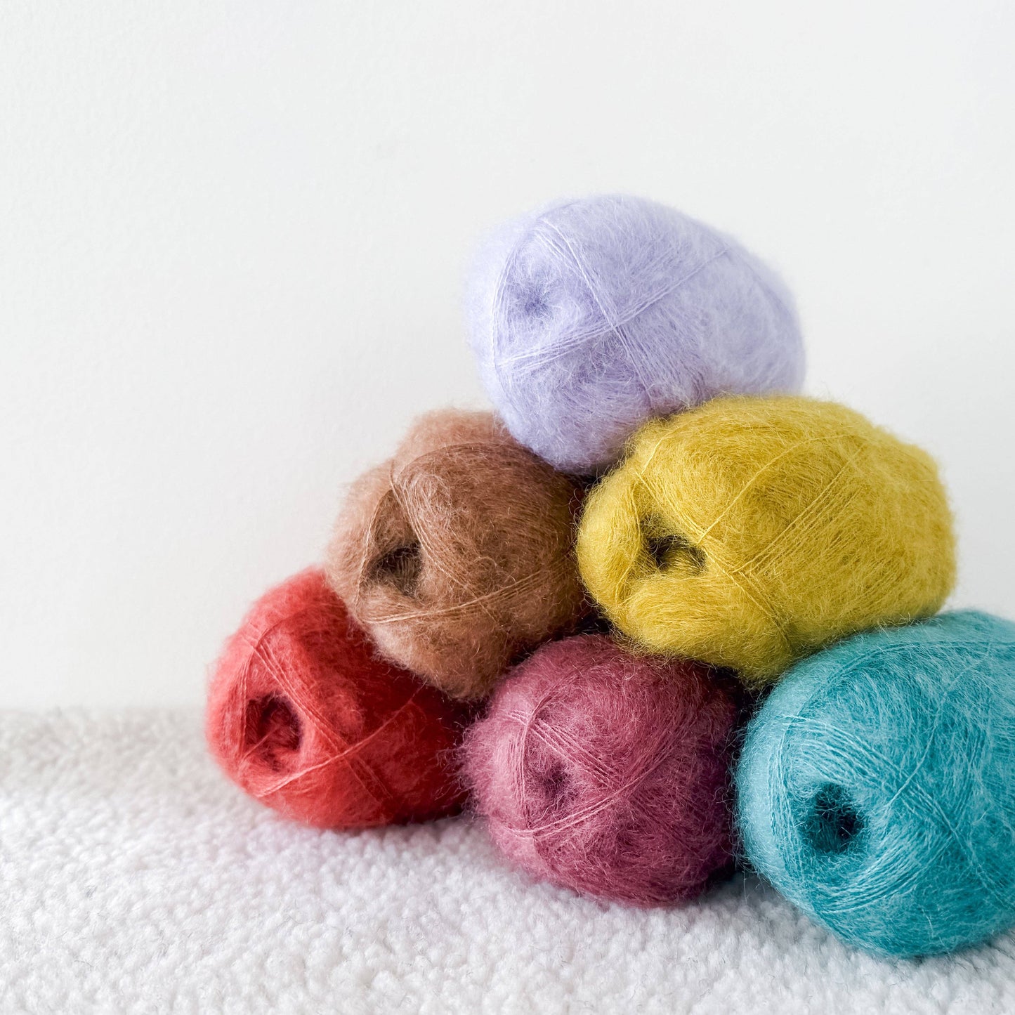 Colorful assortment of Kelbourne Woolens Harmony yarn in various shades for knitting and crafting