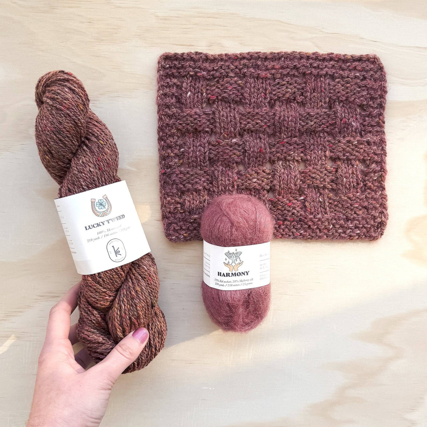 Kelbourne Woolens Harmony yarn in pink next to a knitted swatch and another yarn skein