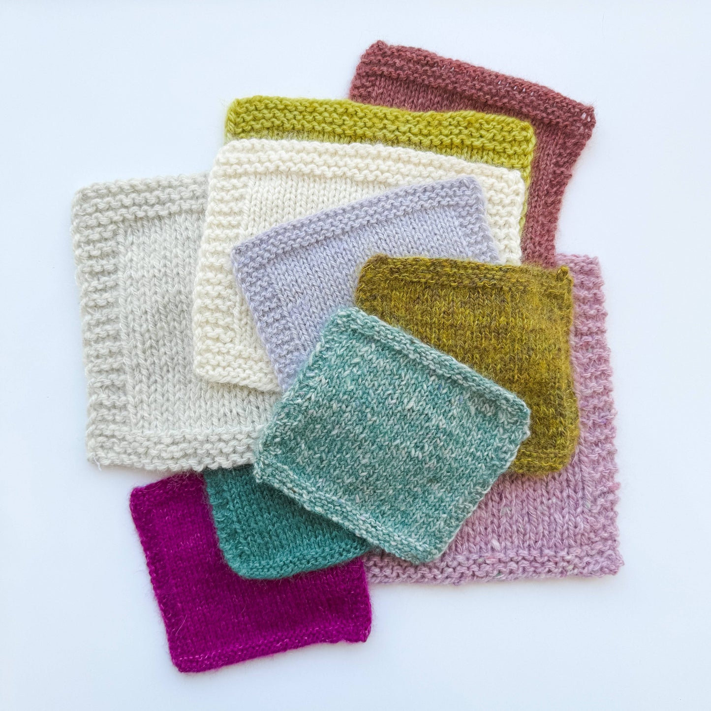 Colorful knitted swatches made with Kelbourne Woolens Harmony yarn showcasing various textures