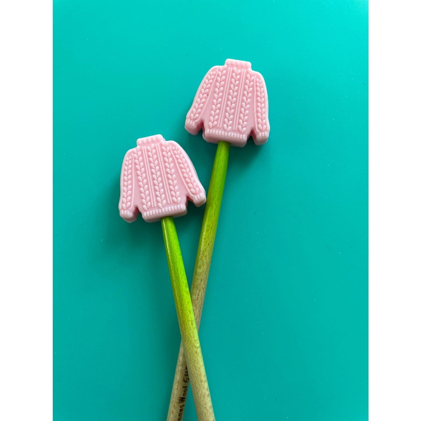 Pink sweater-shaped knitting needle point protectors for securing stitches in knitting projects