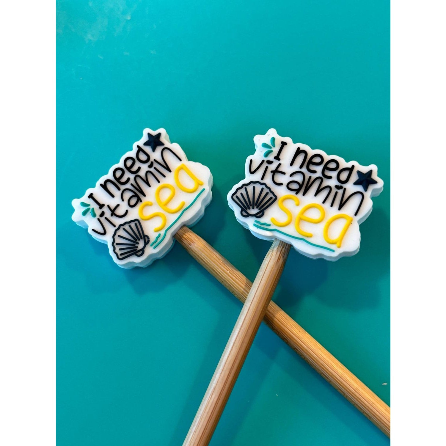 Knitting needles with colorful themed toppers that say I need vitamin sea for fun knitting projects