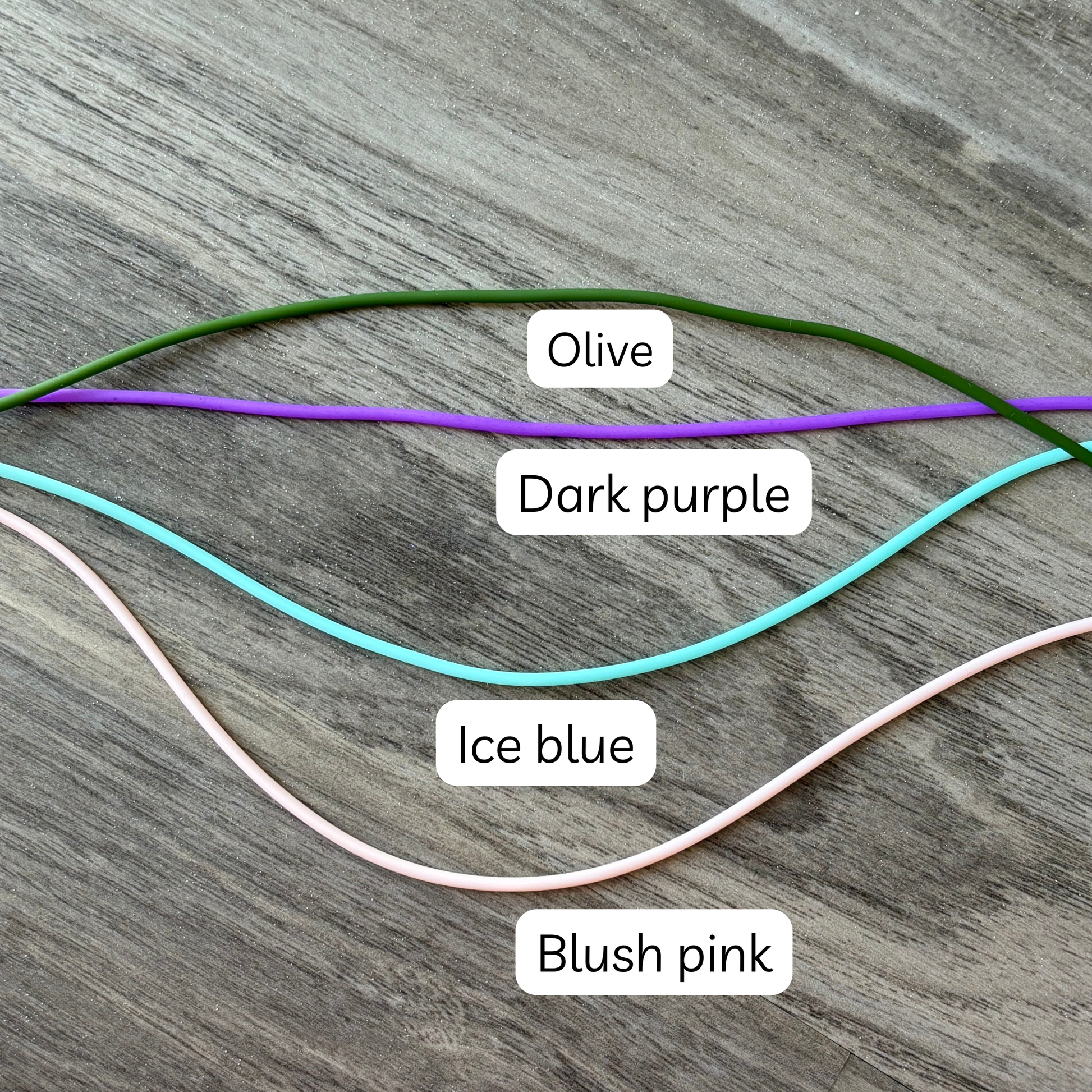 Colorful knitting tools including olive, dark purple, ice blue, and blush pink yarn cords