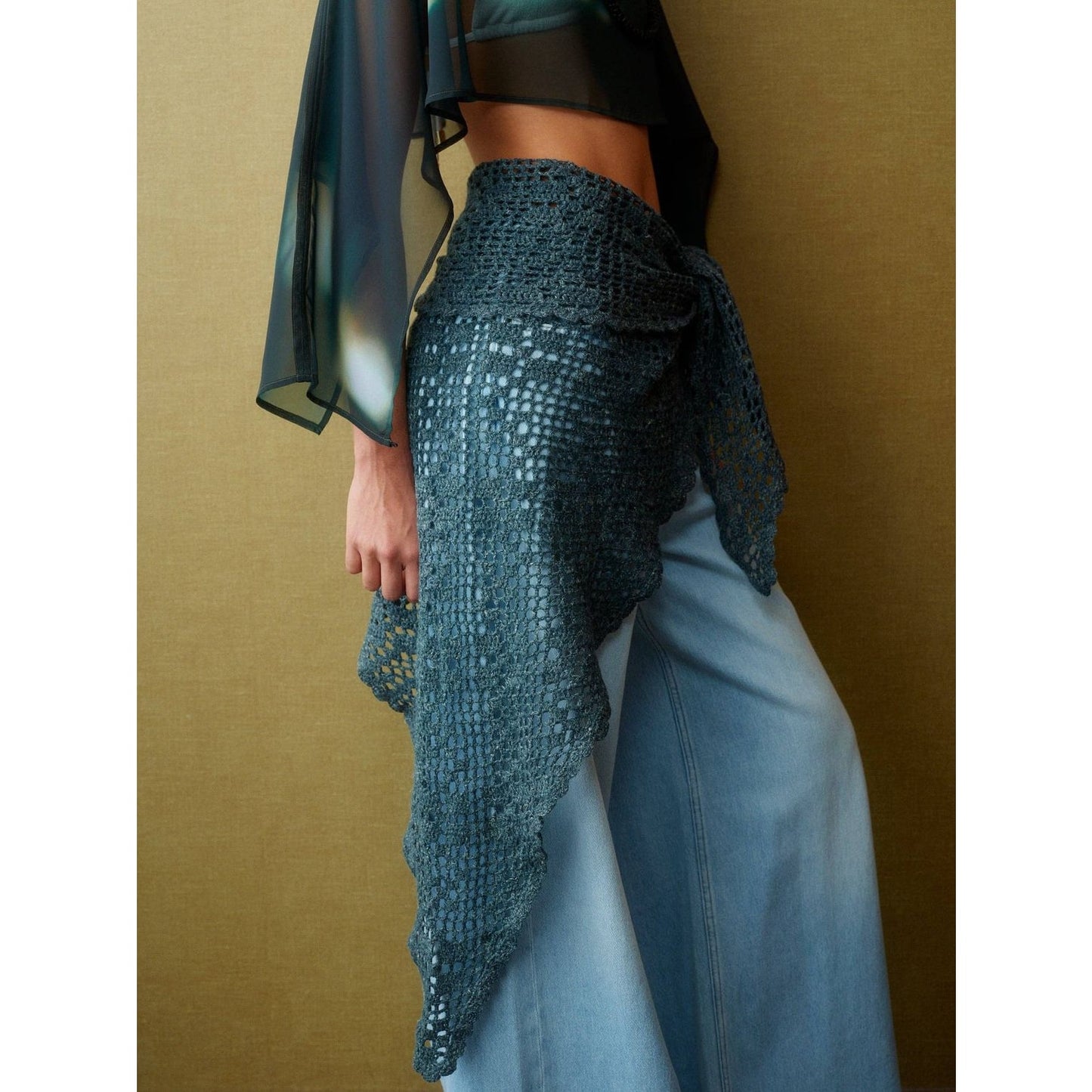 Stylish crochet wrap with patterns modeled on a woman wearing wide-leg jeans