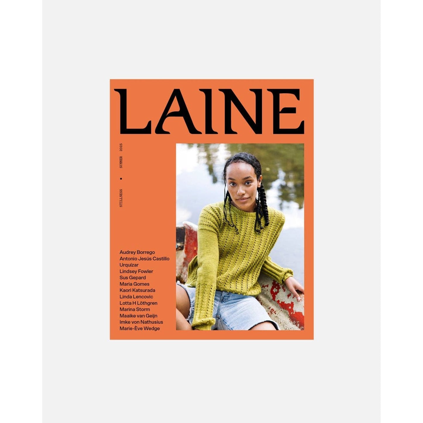 Laine Magazine Issue 25 featuring a model in a green knit sweater by a lake