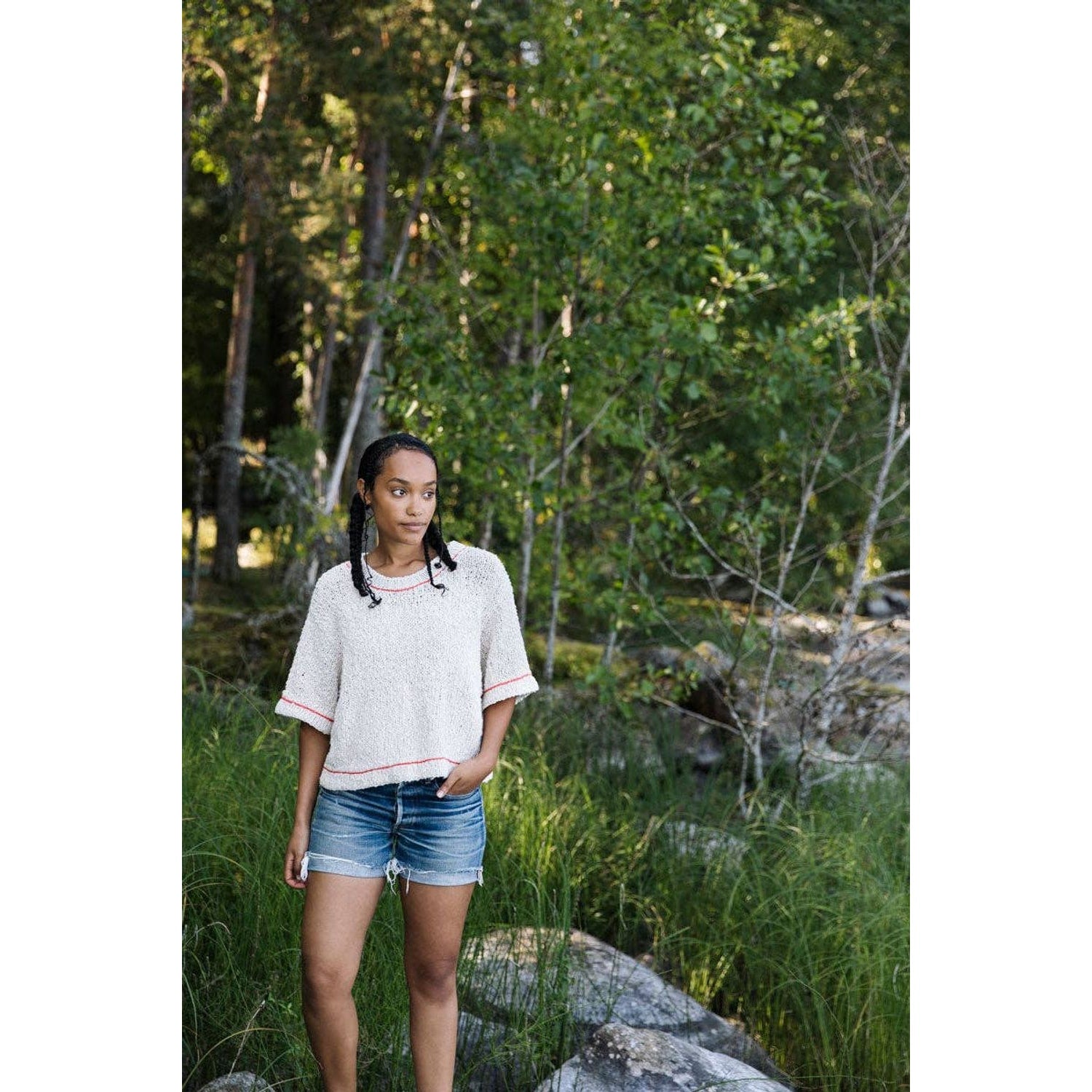 Model wearing a stylish short-sleeve sweater and shorts in a natural setting for Laine Magazine Issue 25