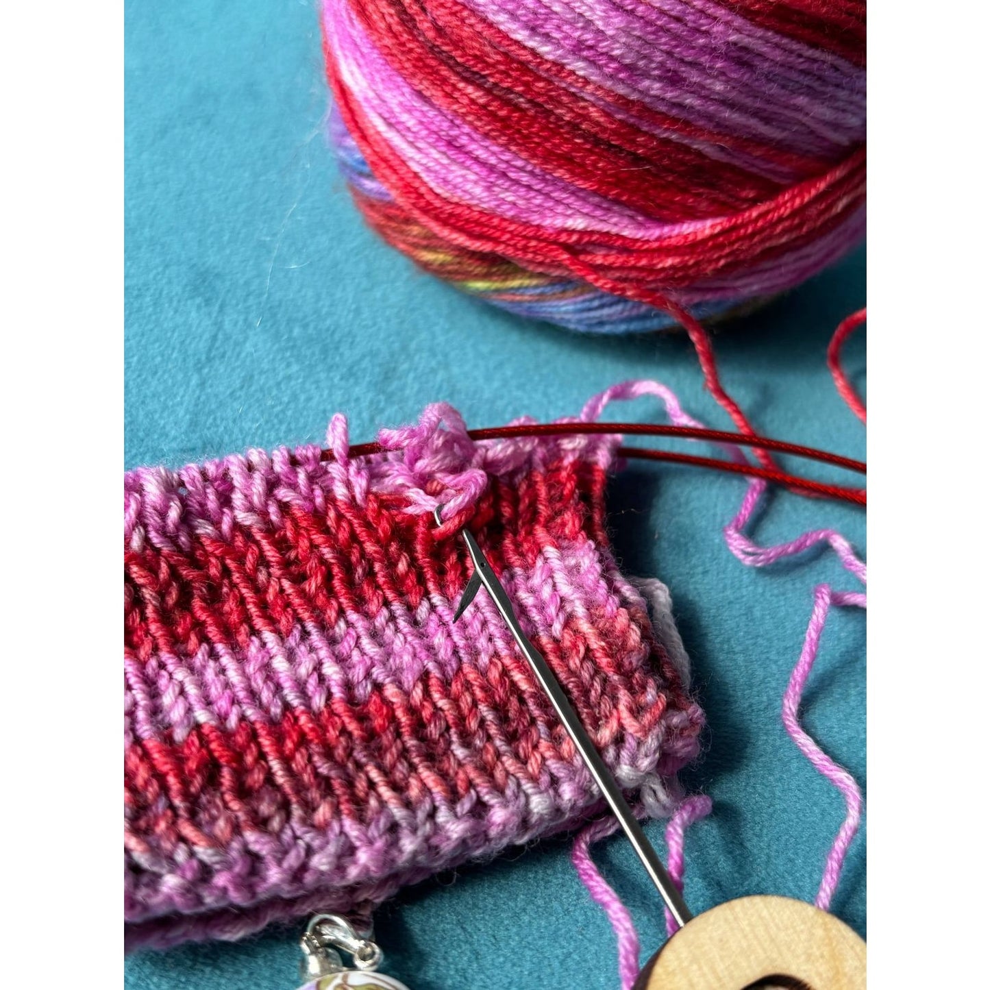 Lemonwood elementary knitting project with vibrant yarn and needle on a blue surface