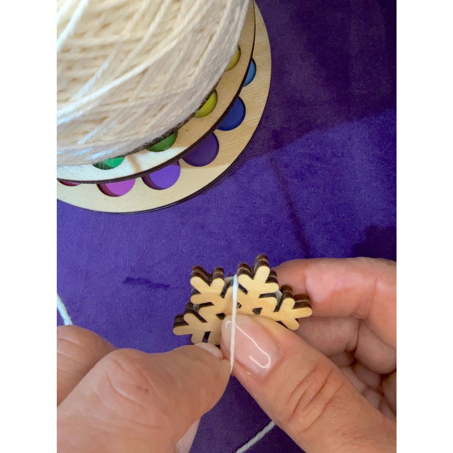 Crafting with Lemonwood Elementary snowflake ornament, hand-stitched with twine and vibrant spool colors
