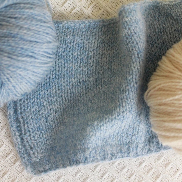Soft blue and cream yarn pieces made from lotus yarns for knitting and crafting projects