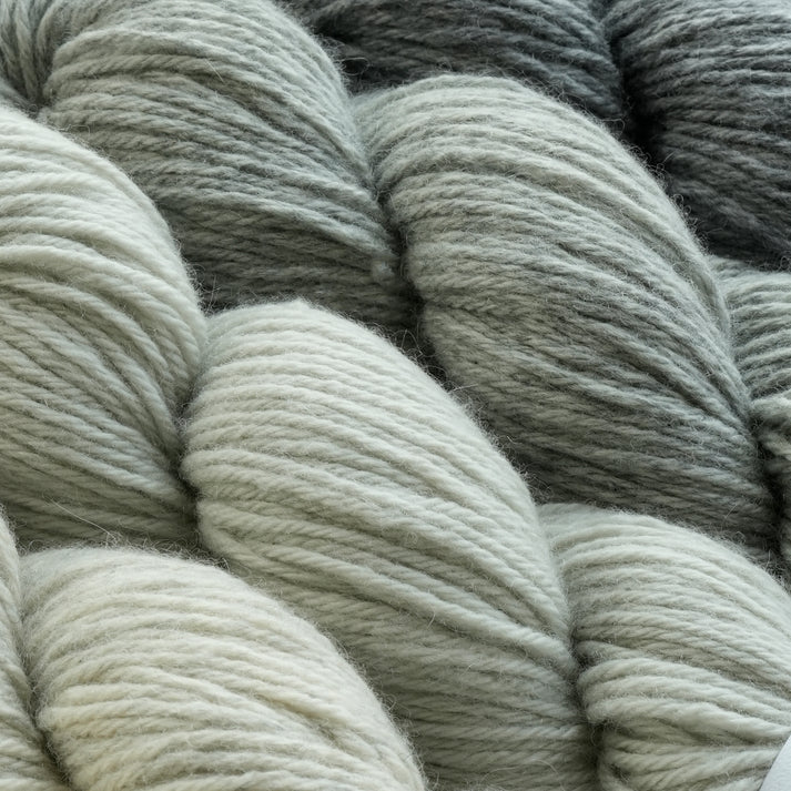 Lotus Yarns DK yarn in soft shades of green and gray for knitting and crochet projects