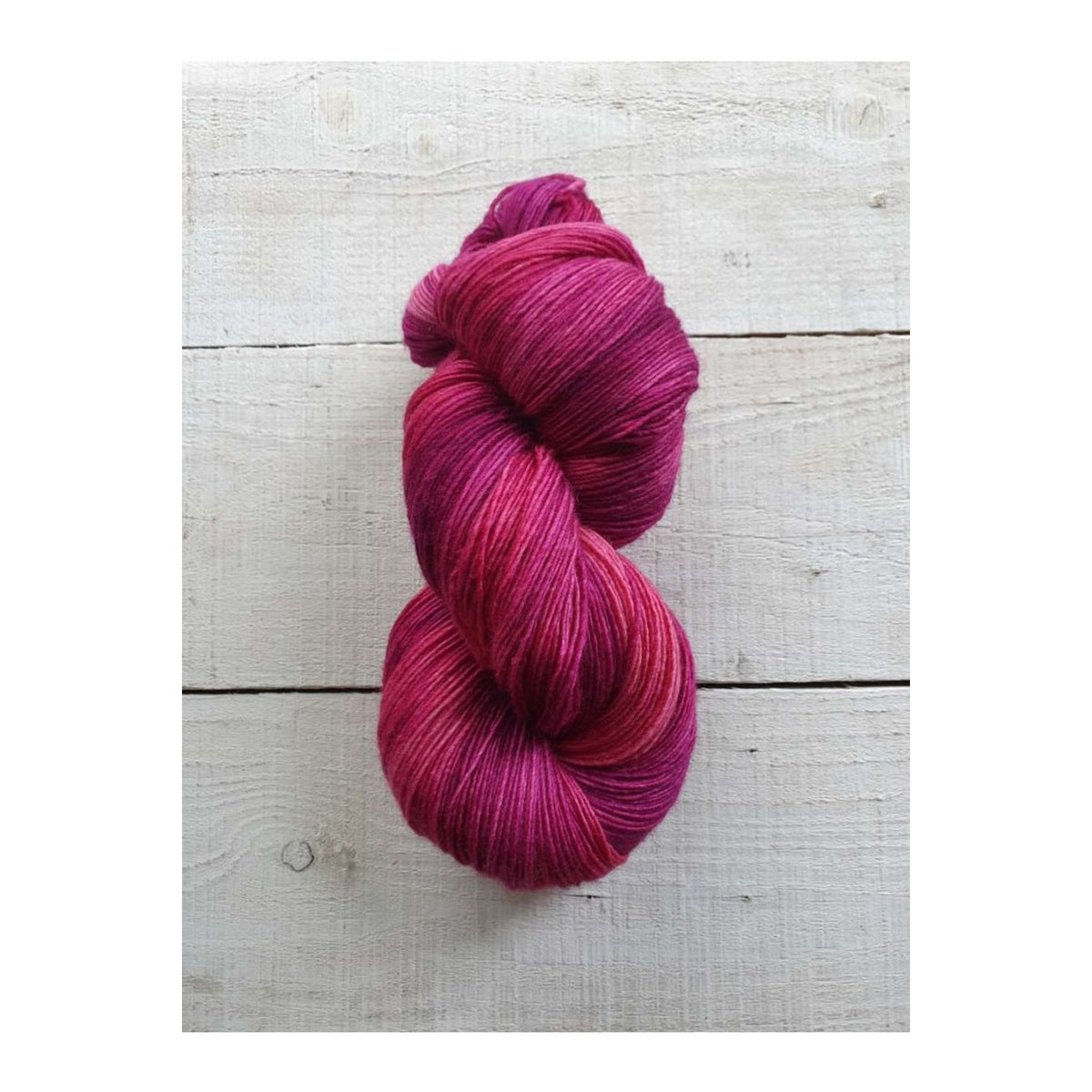 Hand-dyed Manos del Uruguay Fino yarn in vibrant pink and purple hues for knitting and crocheting projects