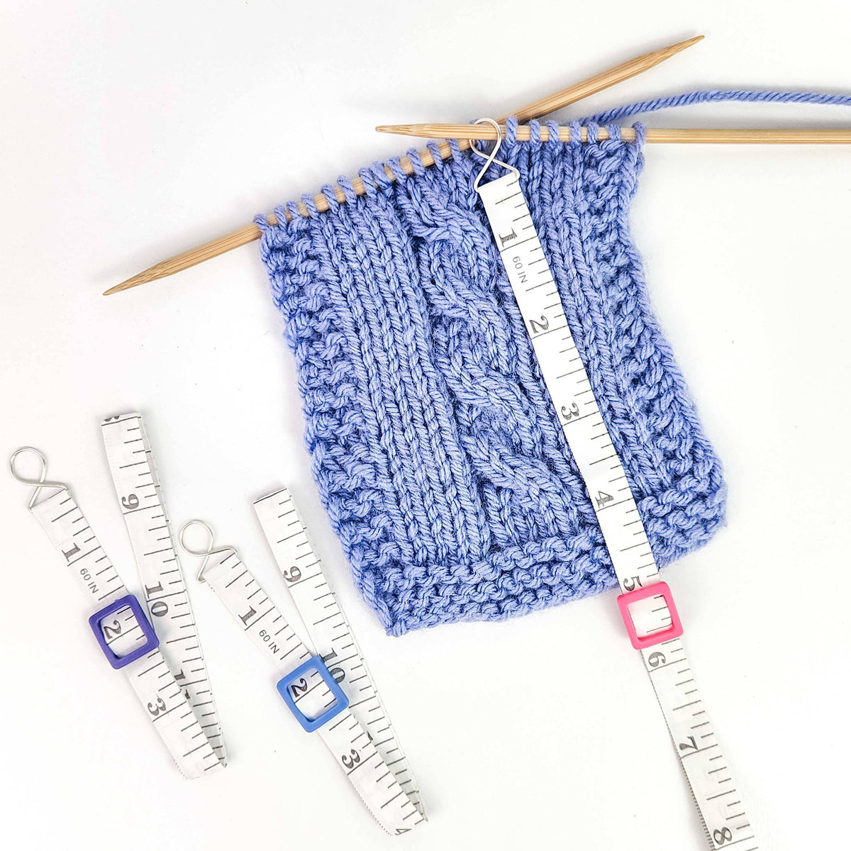 Knitting swatch with measuring tape and stitch markers for measuring with tape accurately